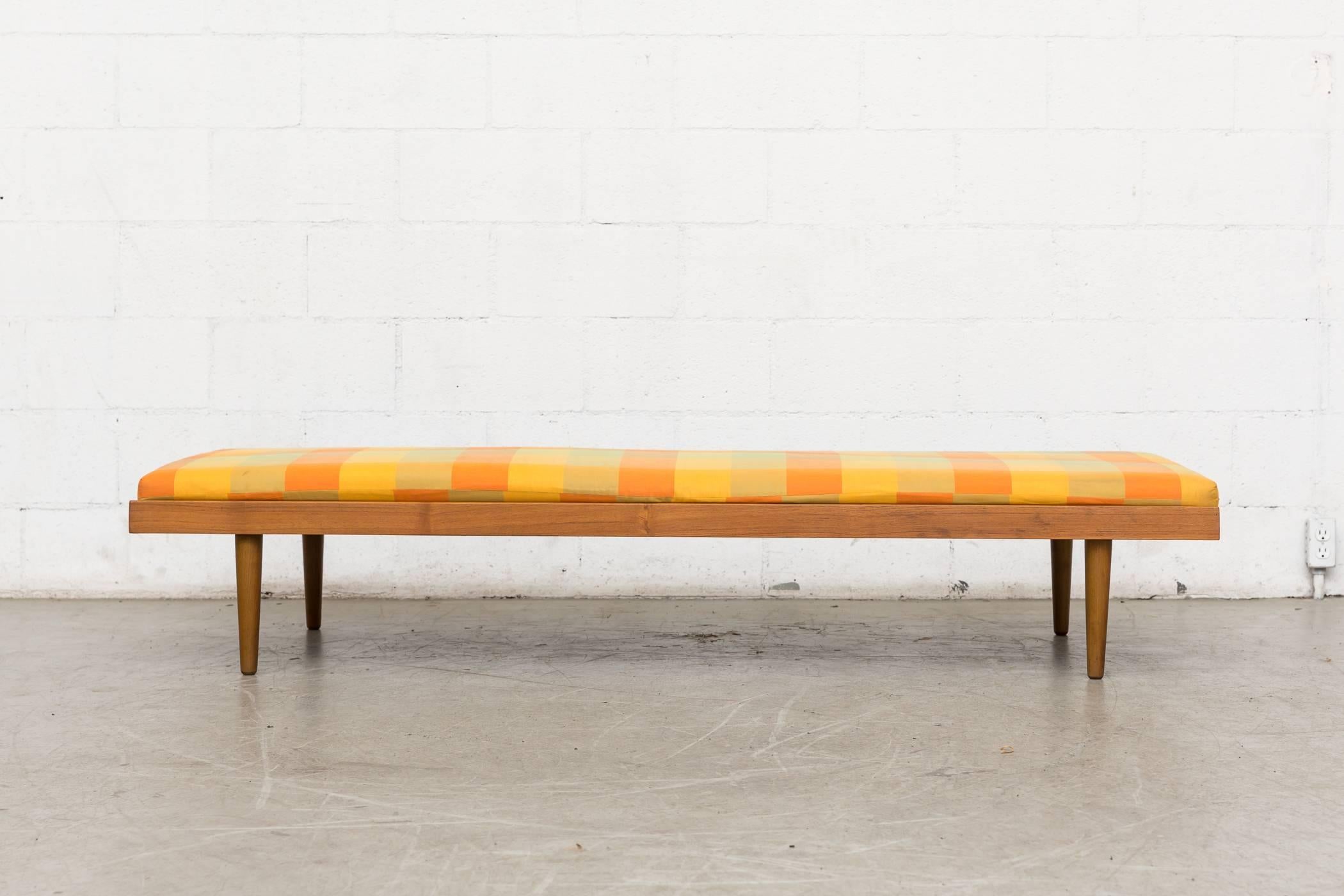 Handsome mid-century Danish teak daybed frame with original vintage yellow/orange/green plaid upholstery. Tapered legs. Lightly refinished. Good original condition.