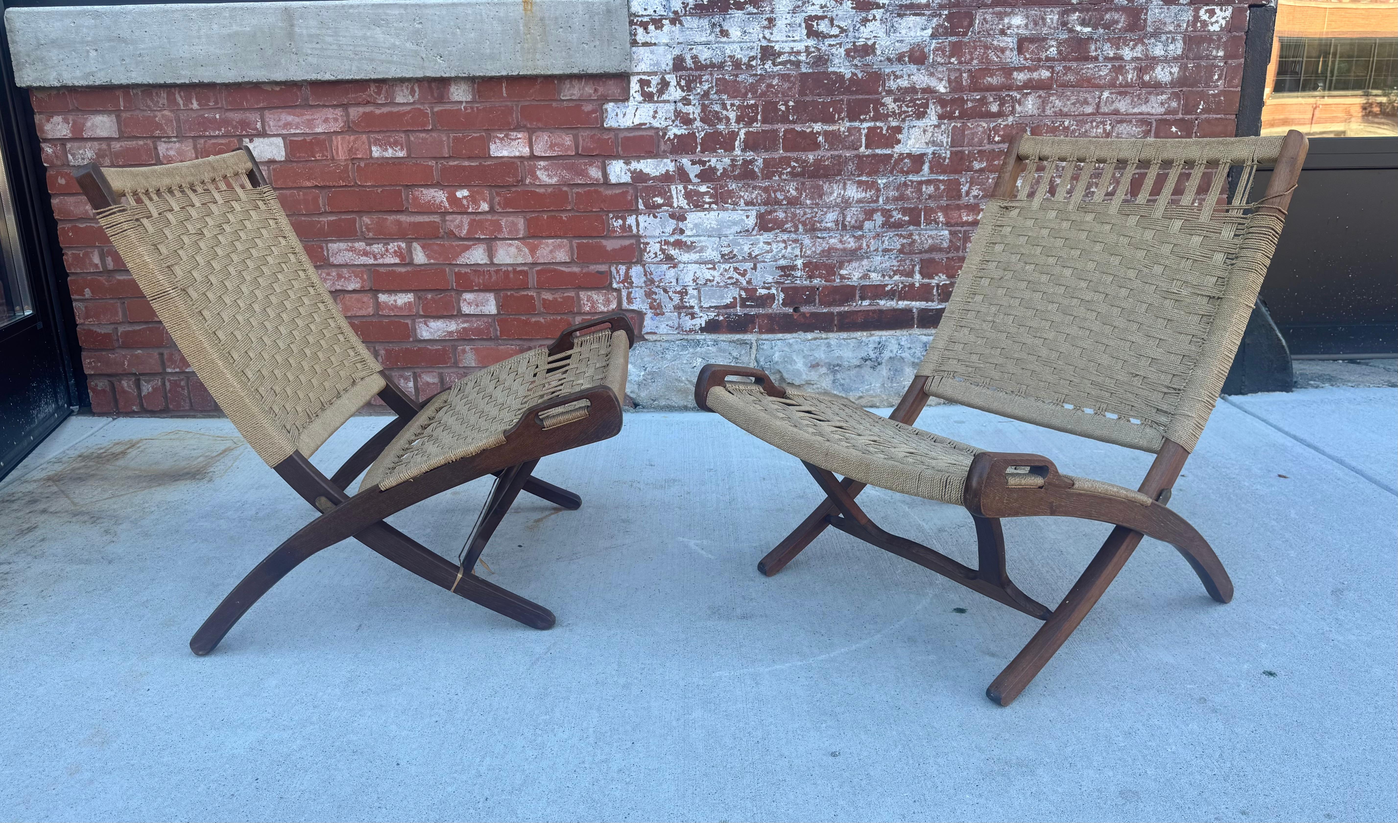 Paar klappbare Loungesessel im Stil von Hans Wegner aus der Mitte des Jahrhunderts, Akzentstühle

Dieses atemberaubende Paar Vintage-Loungesessel verfügt über skulpturale Teakholzrahmen und originale, handgeflochtene Seilsitze und -rückenlehnen