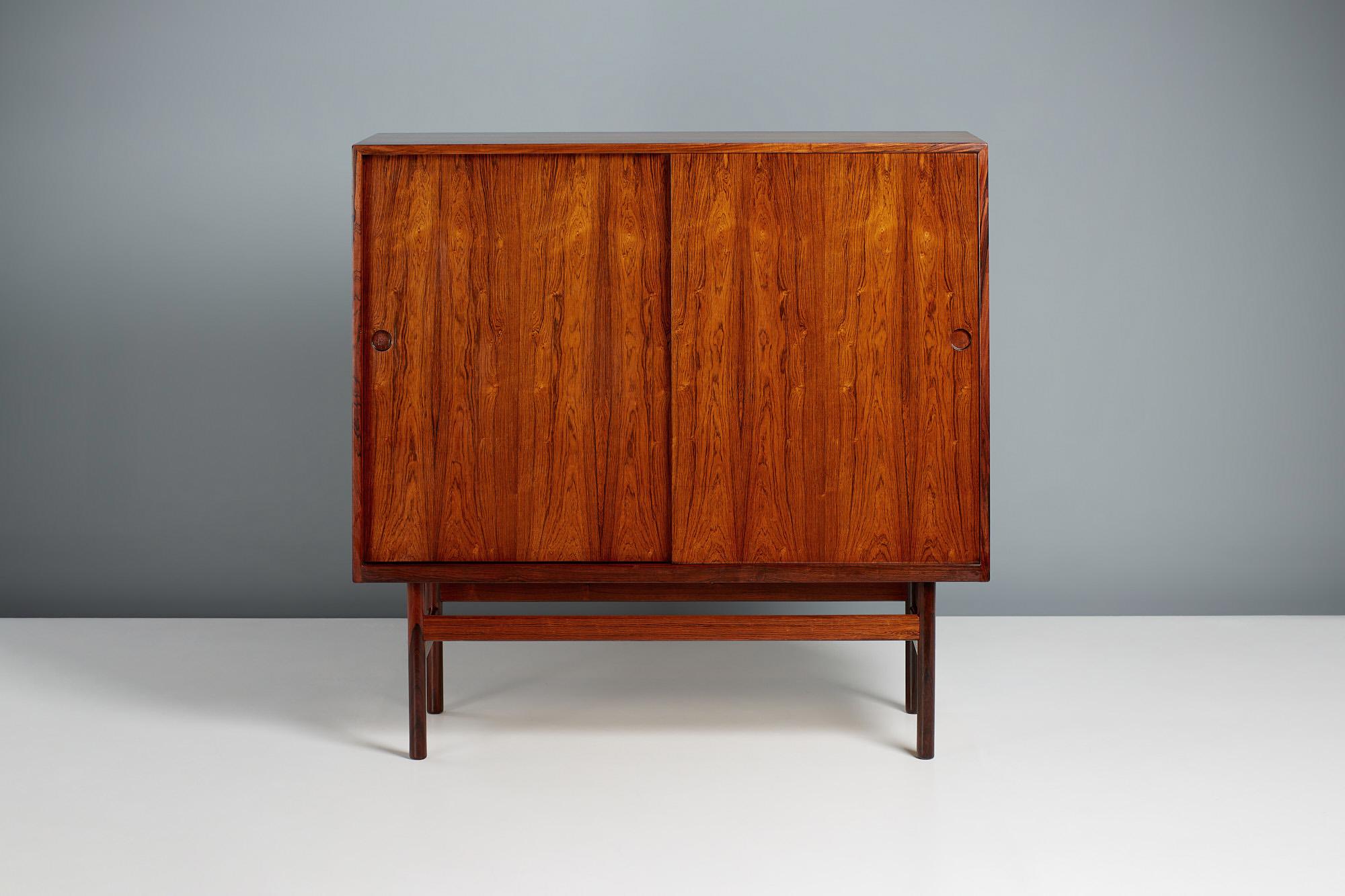 Hans Wegner Tall Cabinet for RY Mobler. 

Exquisite tall cabinet with sliding doors and circular, recessed door pulls probably produced by RY Mobler and designed by Danish mater Hans Wegner. The cabinet is lined with lacquered beech inside and has a