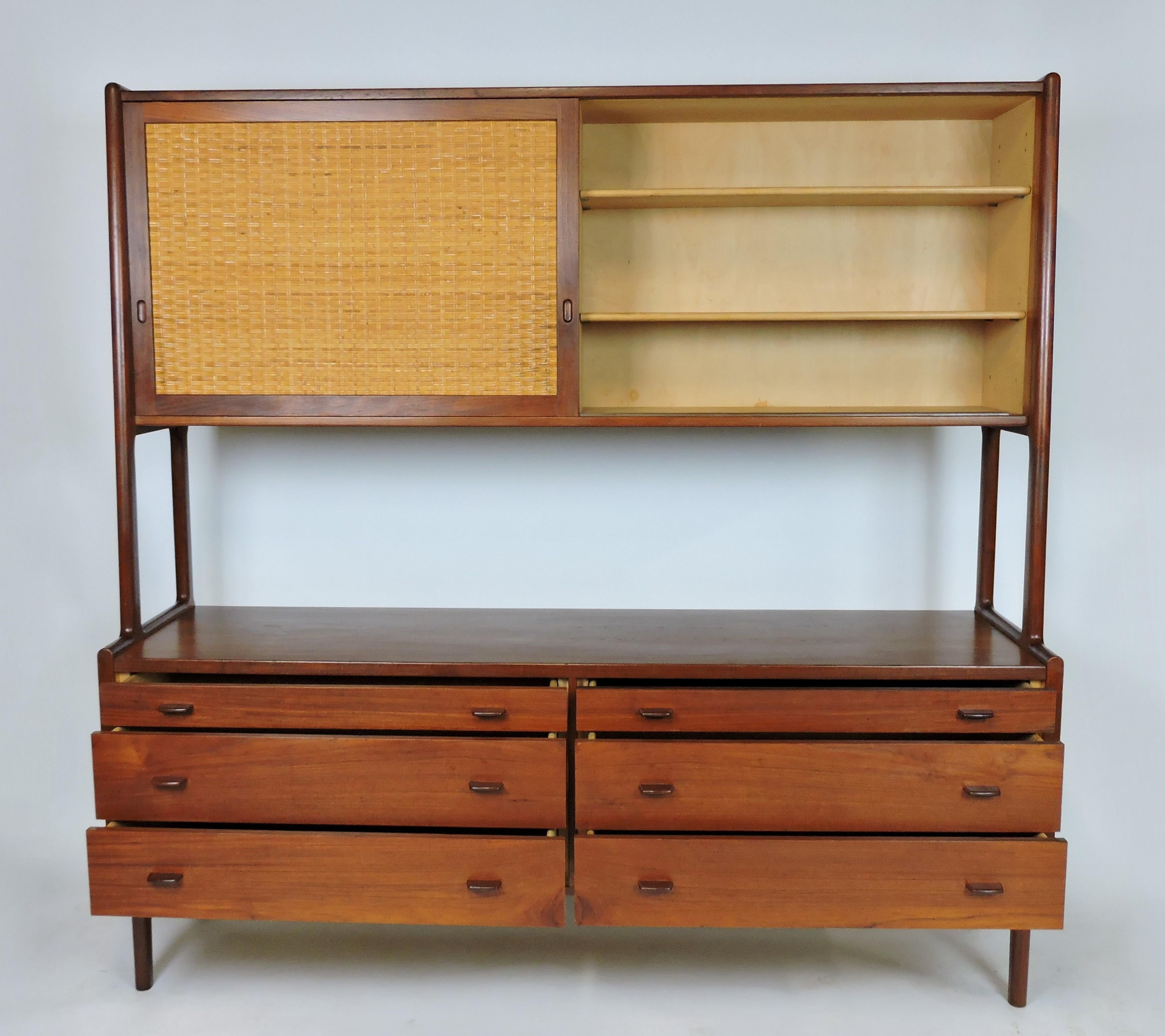 Beautiful two-tier credenza in teak designed by Hans Wegner, manufactured in Denmark by Ry Mobler, and sold through high end retailer, George Tanier. This cabinet has six drawers on the bottom and five adjustable shelves behind two sliding doors