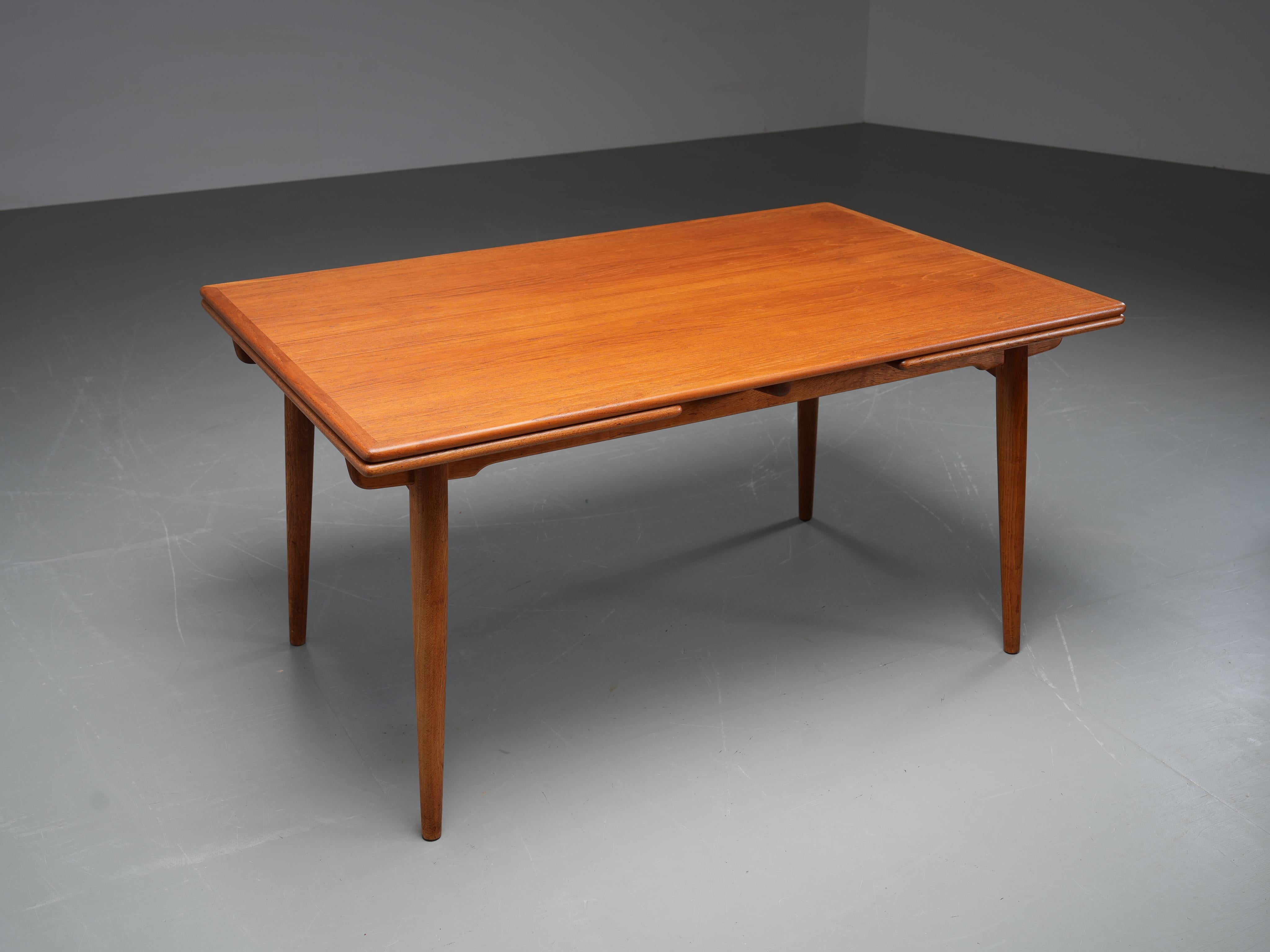 Rare table de salle à manger à rallonge de Hans J. Wegner pour Andreas Tuck, Danemark, années 1960 (marquée). La table présente un plateau en teck reposant sur un cadre en chêne, combinant chaleur et structure d'une manière typique des designs du