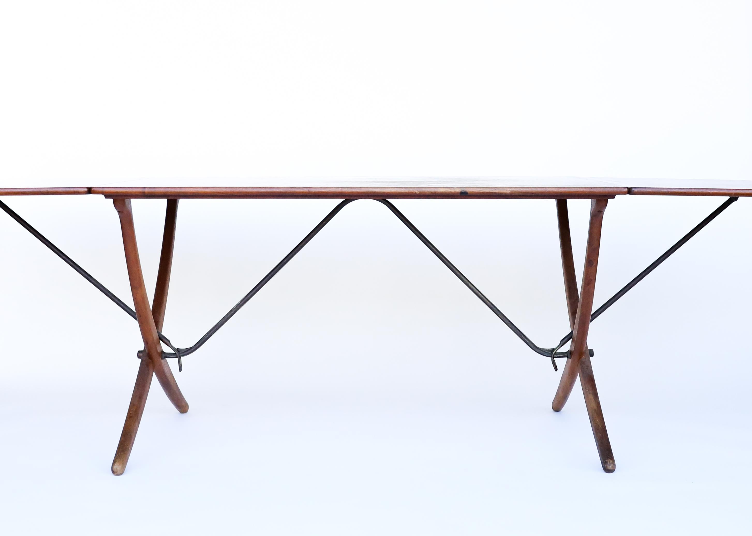 Hans J. Wegner dining table AT-304 with two drop-leaves, cross-legs, and stretchers of brass. Designed by Wegner in 1950's and manufactured by one of Denmark's finest cabinetmakers Andreas Tuck in Denmark. 

Dimensions: 93.50 L x 33.75 W x 28.25H