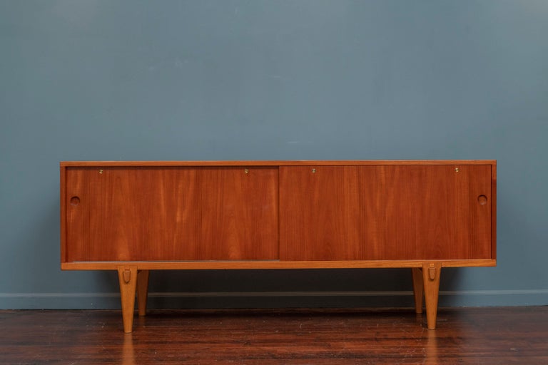 Hans Wegner design teak credenza model RY-26 for RY Mobler, Denmark. High quality construction and attention to detail made with a teak case and oak interior. In very good original condition with very rare sculpted oak legs and original label