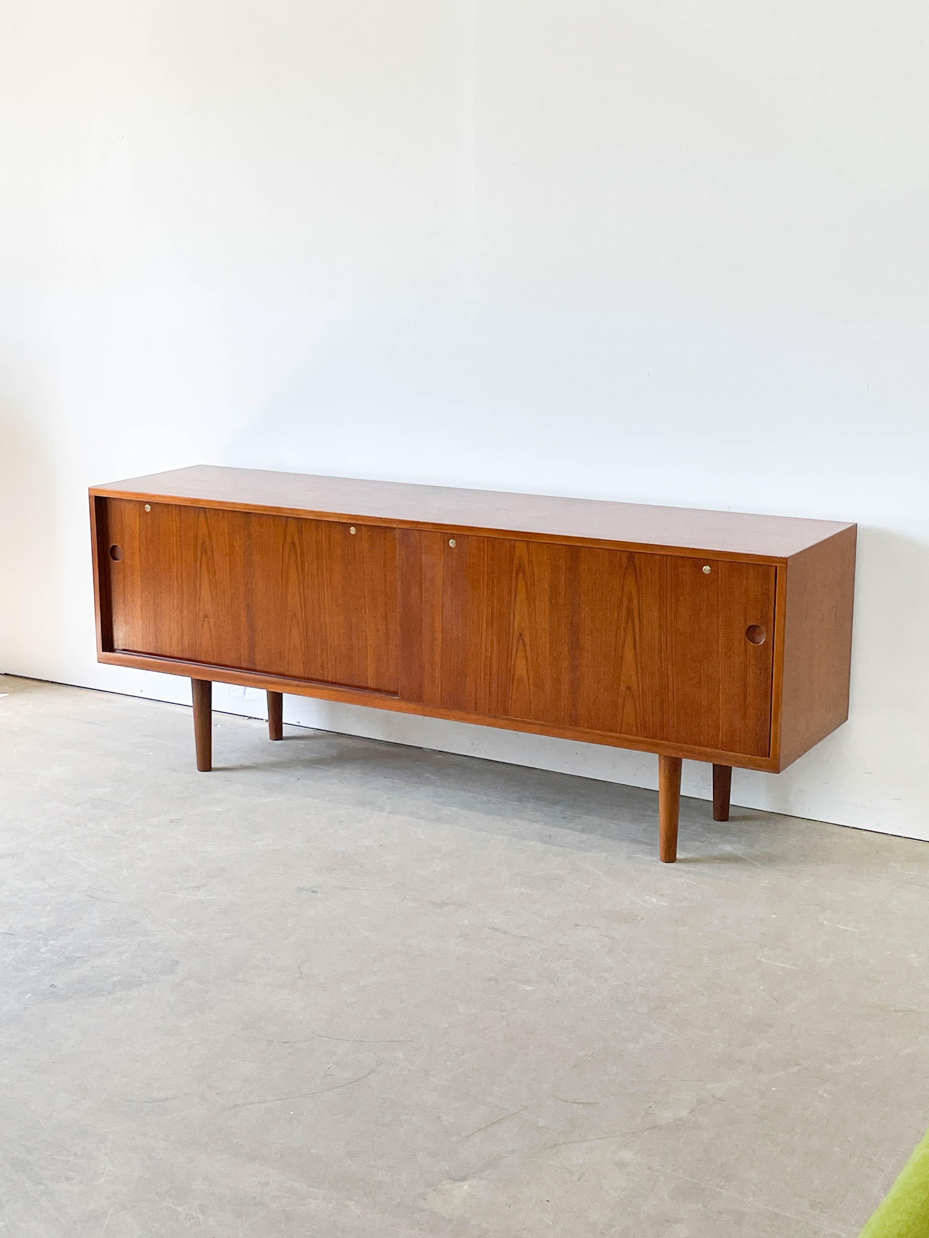 Introducing the Hans Wegner Teak Danish Modern Credenza RY26, a stunning piece of mid-century modern furniture that embodies elegance and functionality. The exquisite credenza is crafted from high-quality teak wood, showcasing the natural beauty and