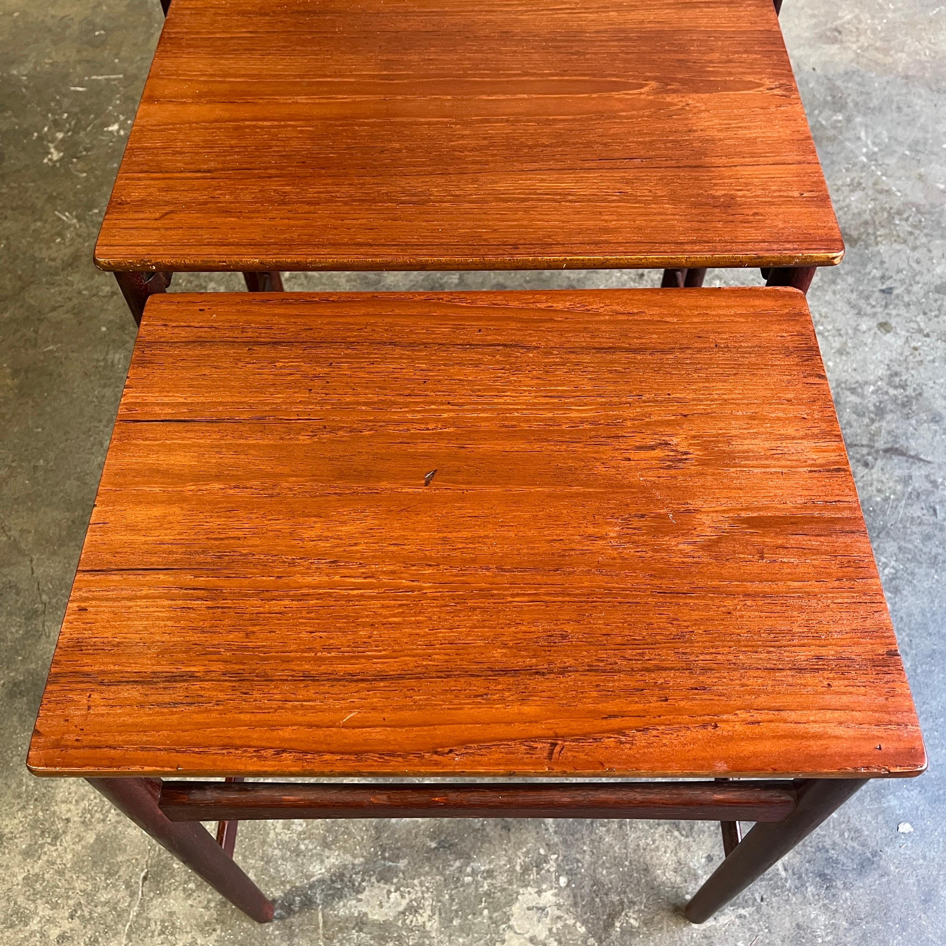 Danish modern teak nesting tables, designed by Hans Wegner for Andreas Tuck, Denmark, circa 1950s. They have been cleaned and Danish oiled with age appropriate wear and nice patina.

   