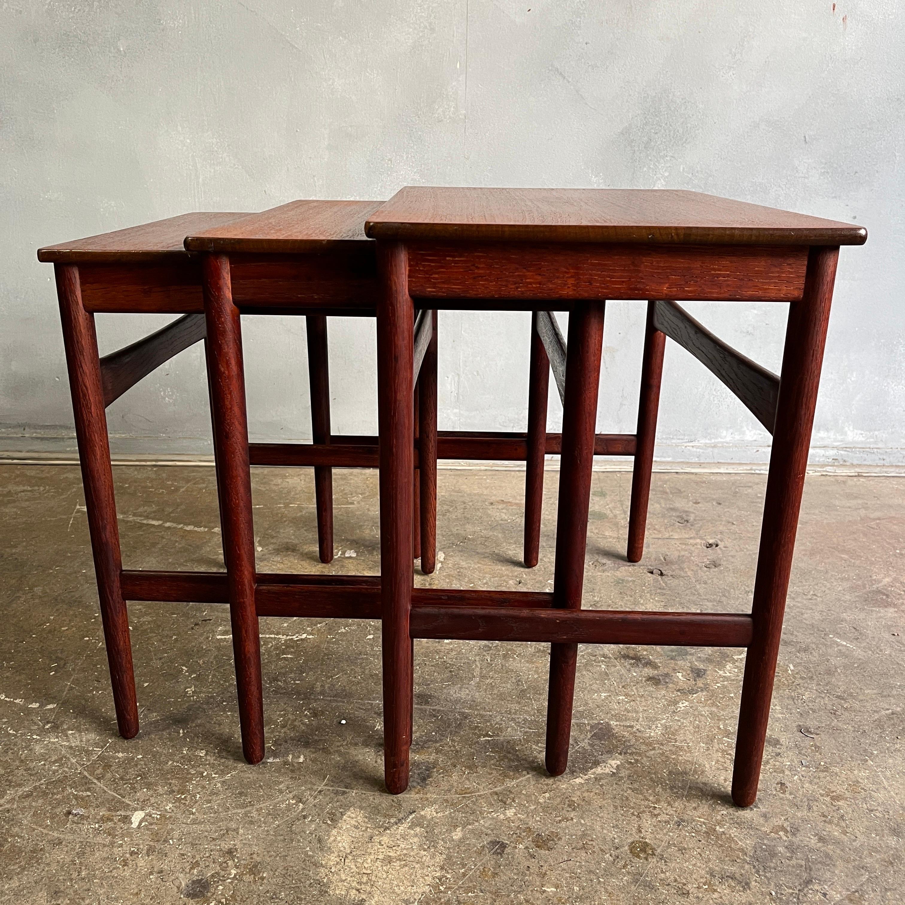 A set of three Hans J. Wegner nesting tables with frame of patinated oak and teak top. Good condition with original patina. Manufactured and stamped by Andreas Tuck, model AT40. 

