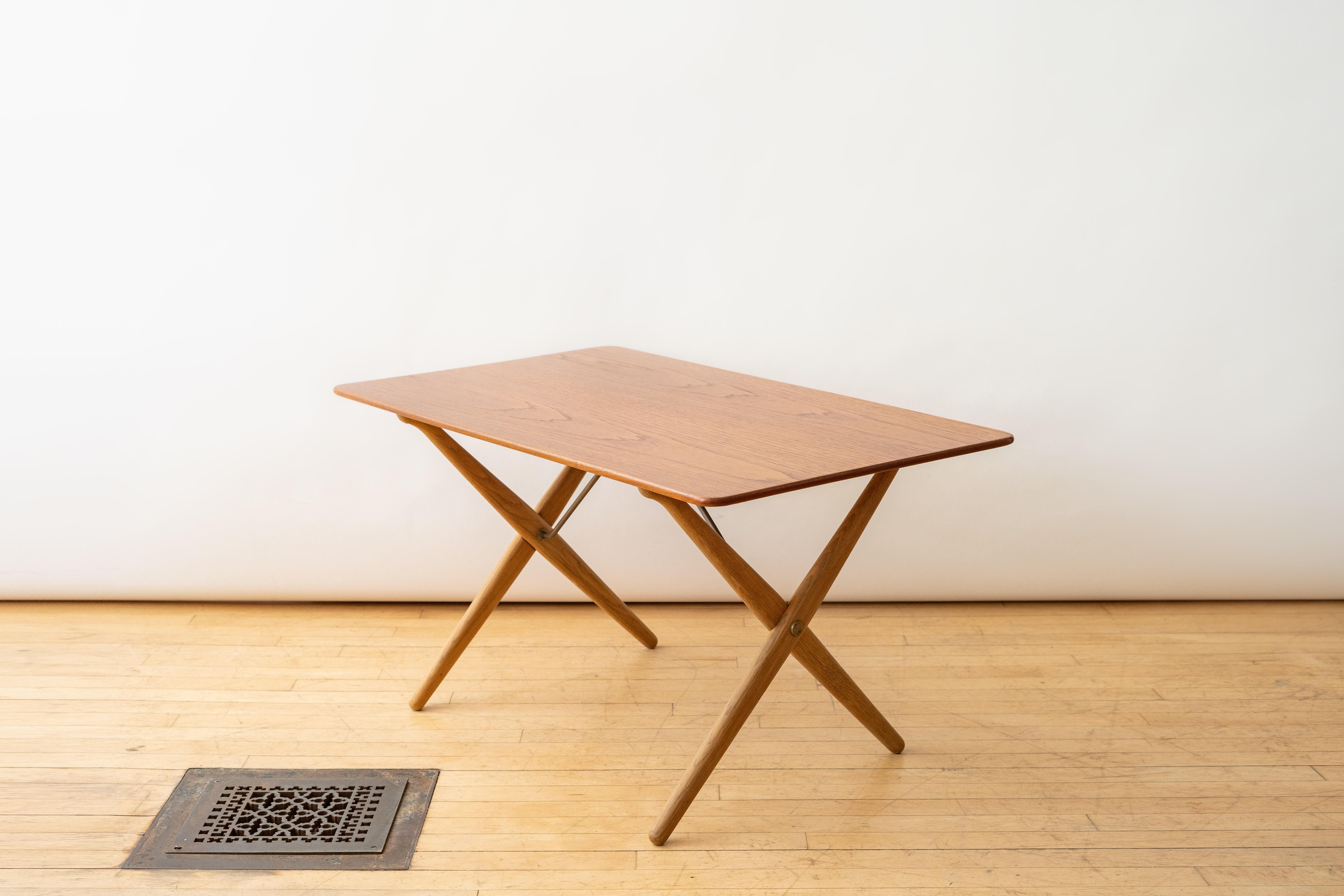 
Danemark, vers les années 1950. Rare table basse AT-308 de Hans Wegner pour Andreas Tuck. Le plateau rectangulaire en teck est soutenu par des pieds en X en chêne massif avec des supports et des ferrures tubulaires en laiton. Elegant et révélateur