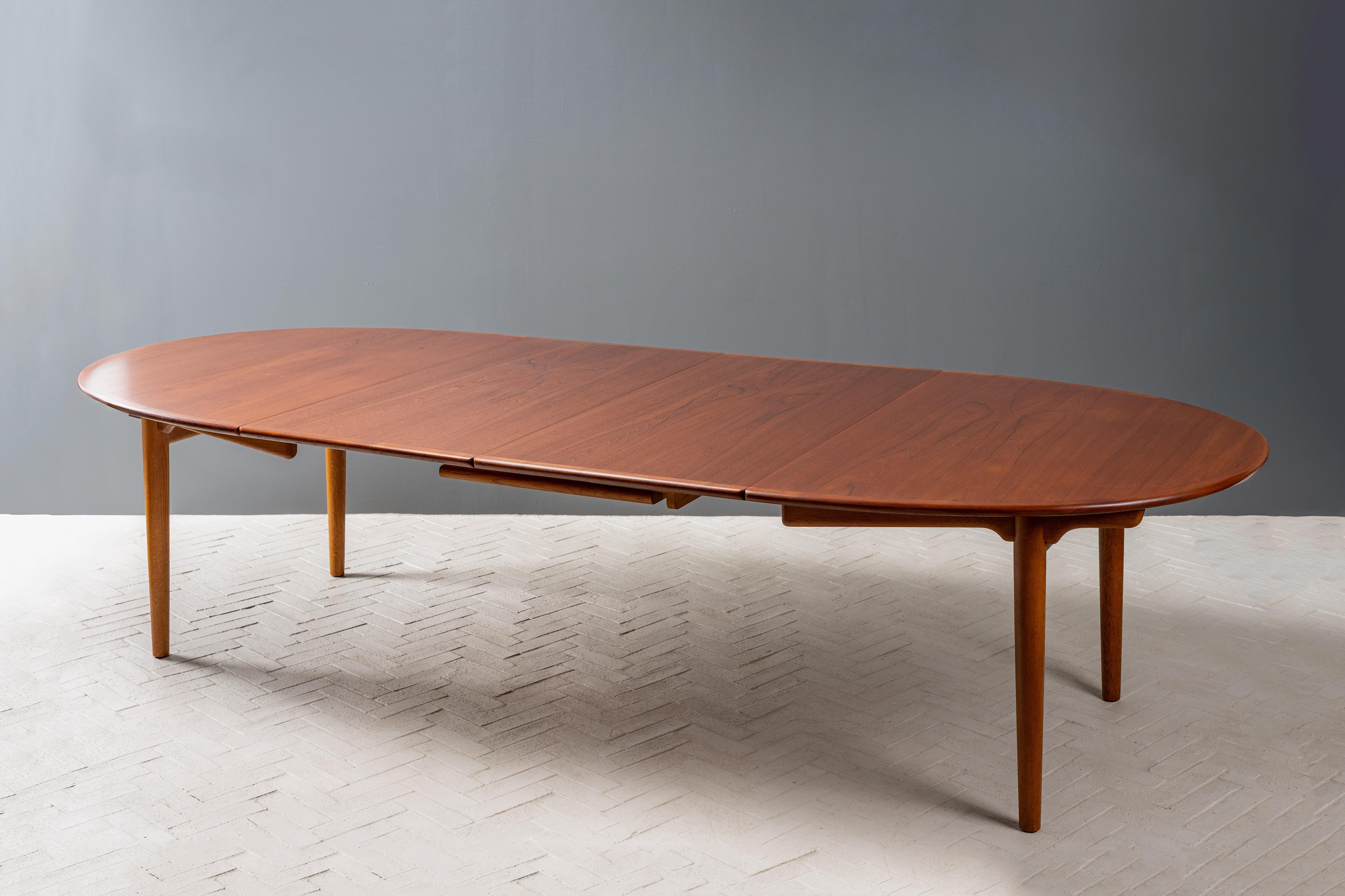 Dinamarca, hacia la década de 1950. Una antigua y rara mesa de comedor grande de Hans Wegner, fabricada por el ebanista Johannes Hansen. Presenta una tapa ovalada de teca antigua apoyada en una base orgánica de roble blanco de estilo casi Shaker.