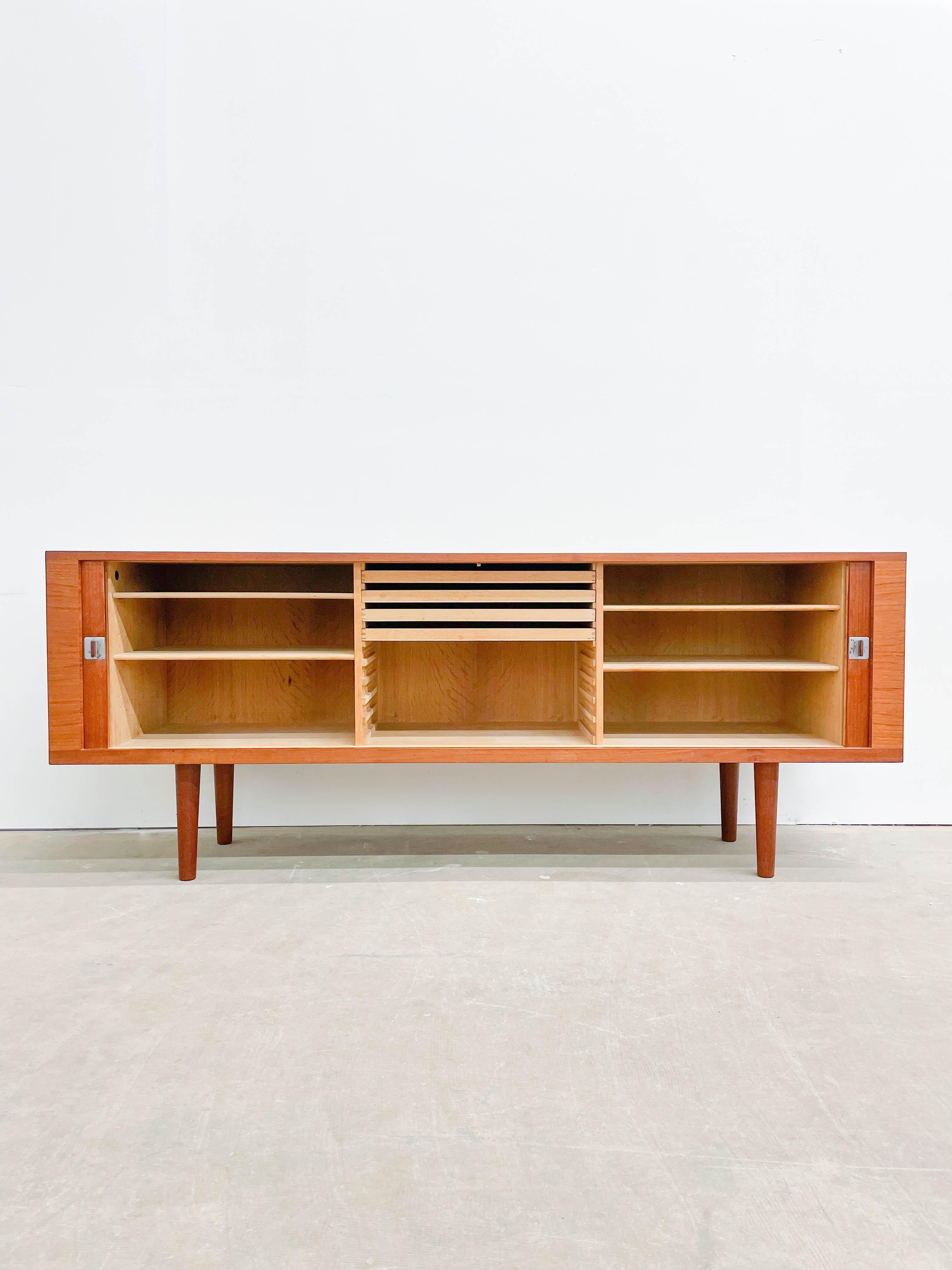Excellent tambour front credenza designed by the master Hans Wegner for RY Mobler in the 1960s. Beautiful teak case with quartersawn oak interior behind a superb tambour door. Teak pulls with chrome plates add a touch of glamour. This piece is in