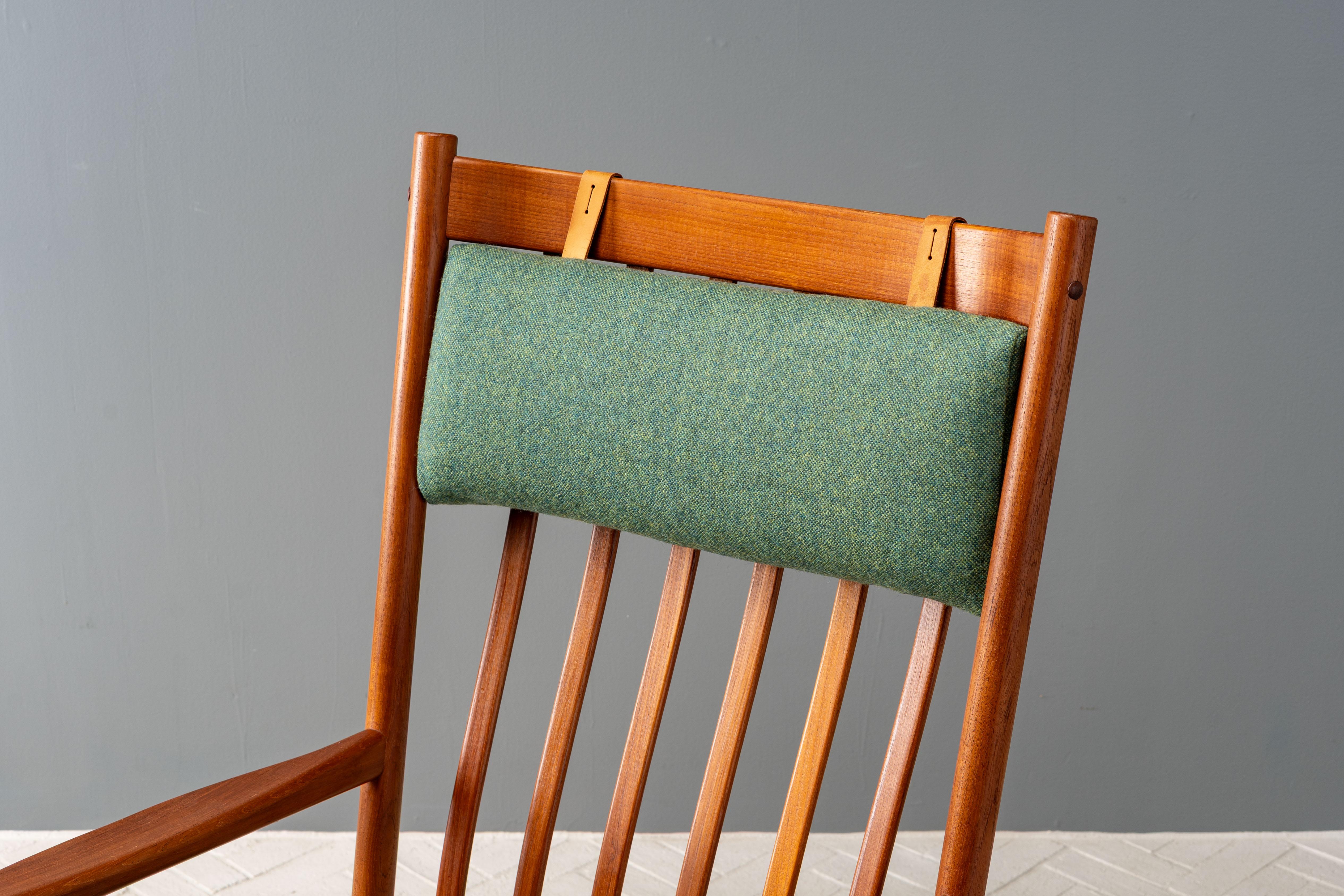 Denmark, ca. 1970s. An accommodating and quite comfortable rocking chair designed by Hans Wegner for Tarm Stole Møbelfabrik. Features solid teak frame with elegantly contoured high backrest and flared arms. Generous seat and adjustable head pillow