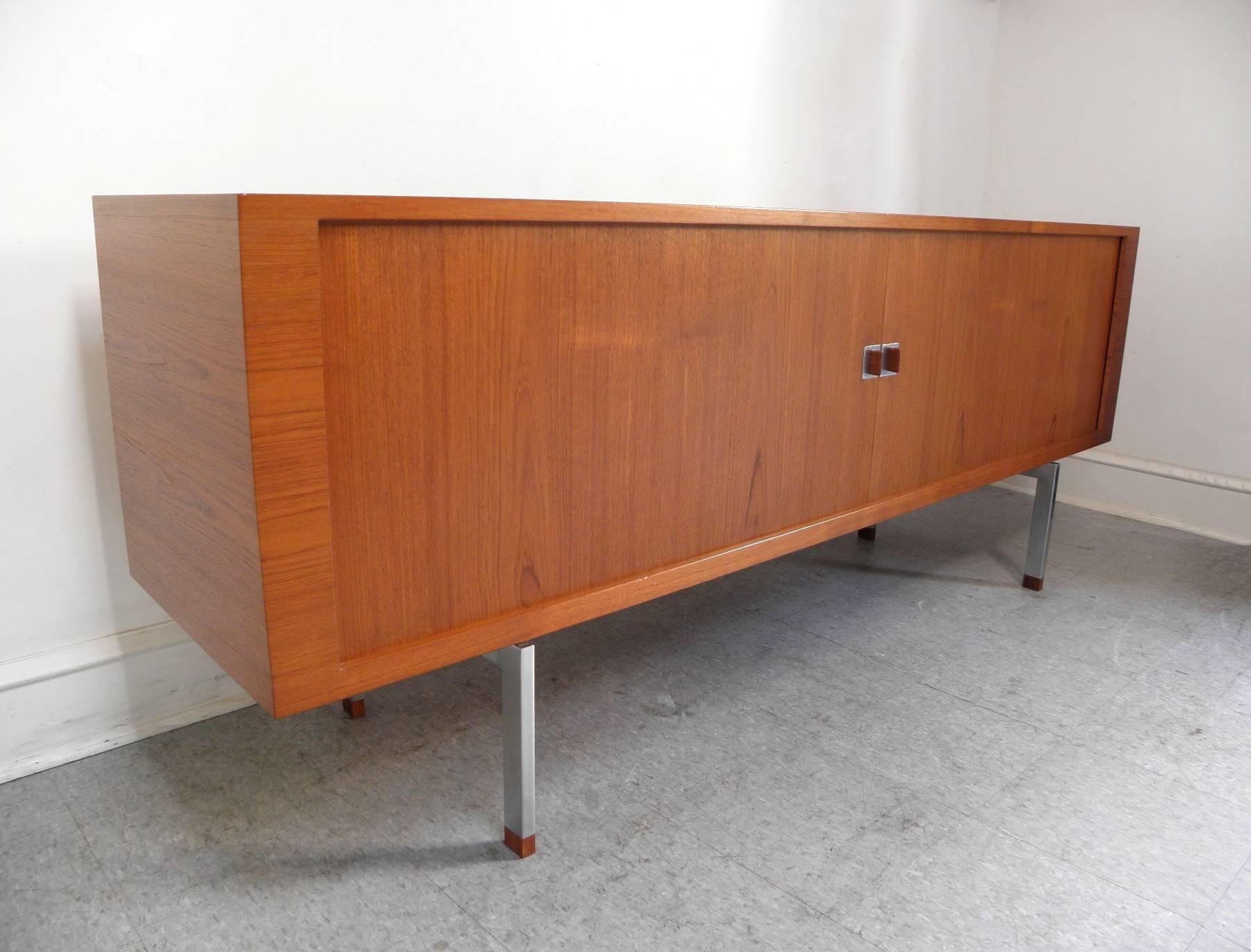 Handsome President credenza in teak designed by Hans Wegner and manufactured in Denmark by Ry Mobler. This credenza has tambour doors and stainless steel legs and accents.