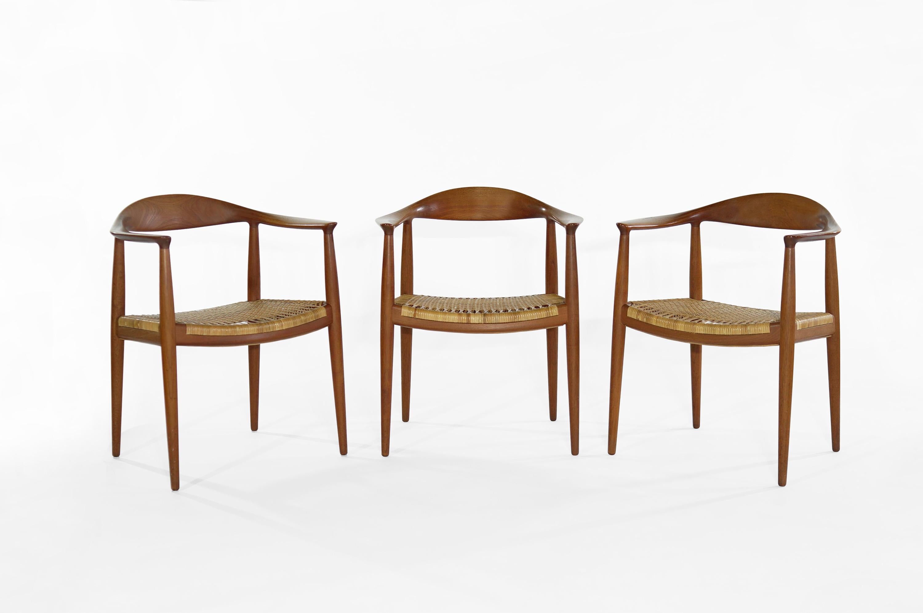 Hans Wegner's iconic round chair, model JH 501, made by Johannes Hansen, Denmark, 1949.
Commonly known as 'The Chair', these are an early teak version with cane seat. Branded with makers mark. Priced as a set.