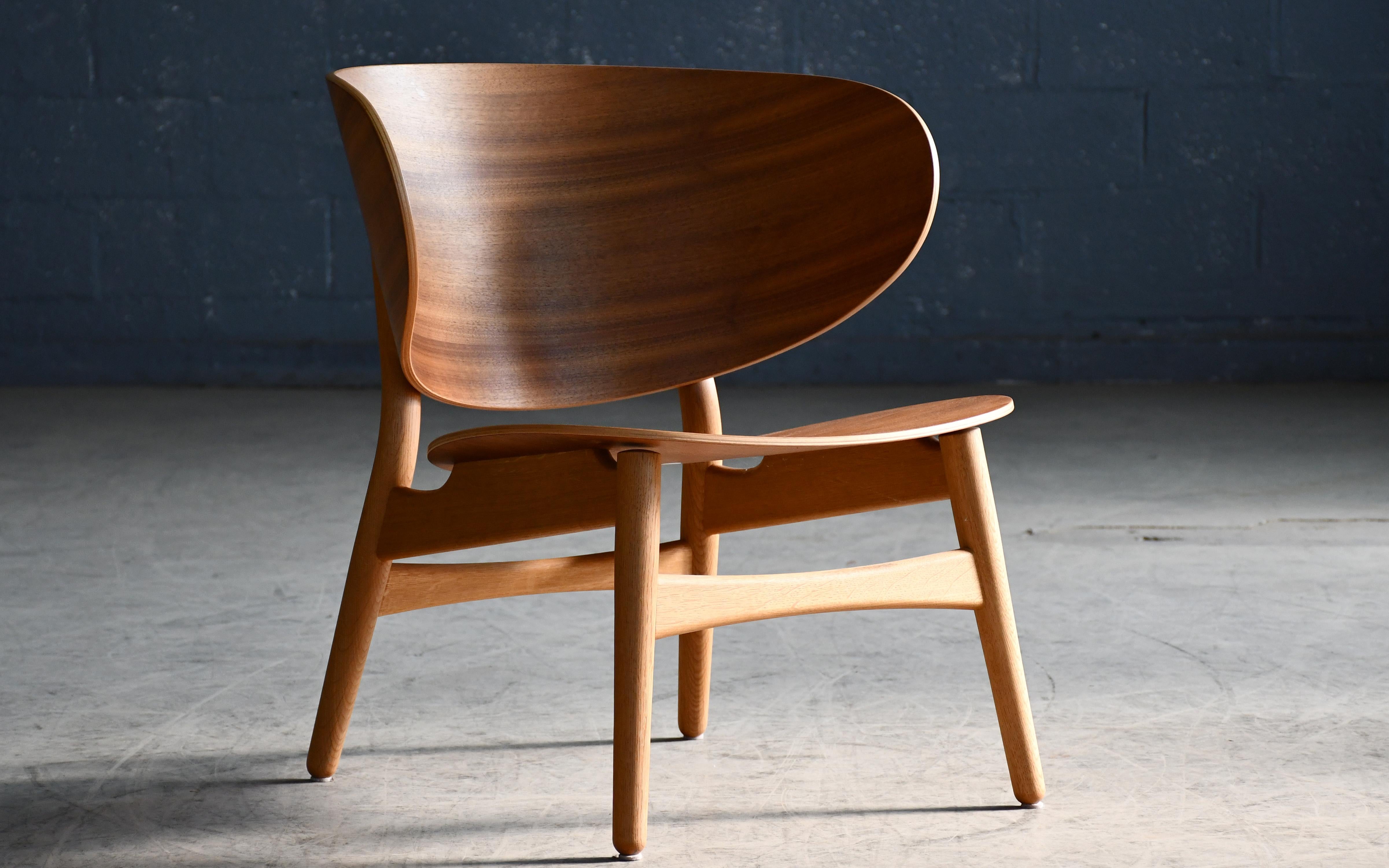 Cette fantastique chaise coquille avec dossier et assise en placage de noyer sur une base en chêne traité au savon est une réédition 2015 par GETAMA de la chaise classique conçue par Hans Wegner en 1948. Alors que le design original comportait du
