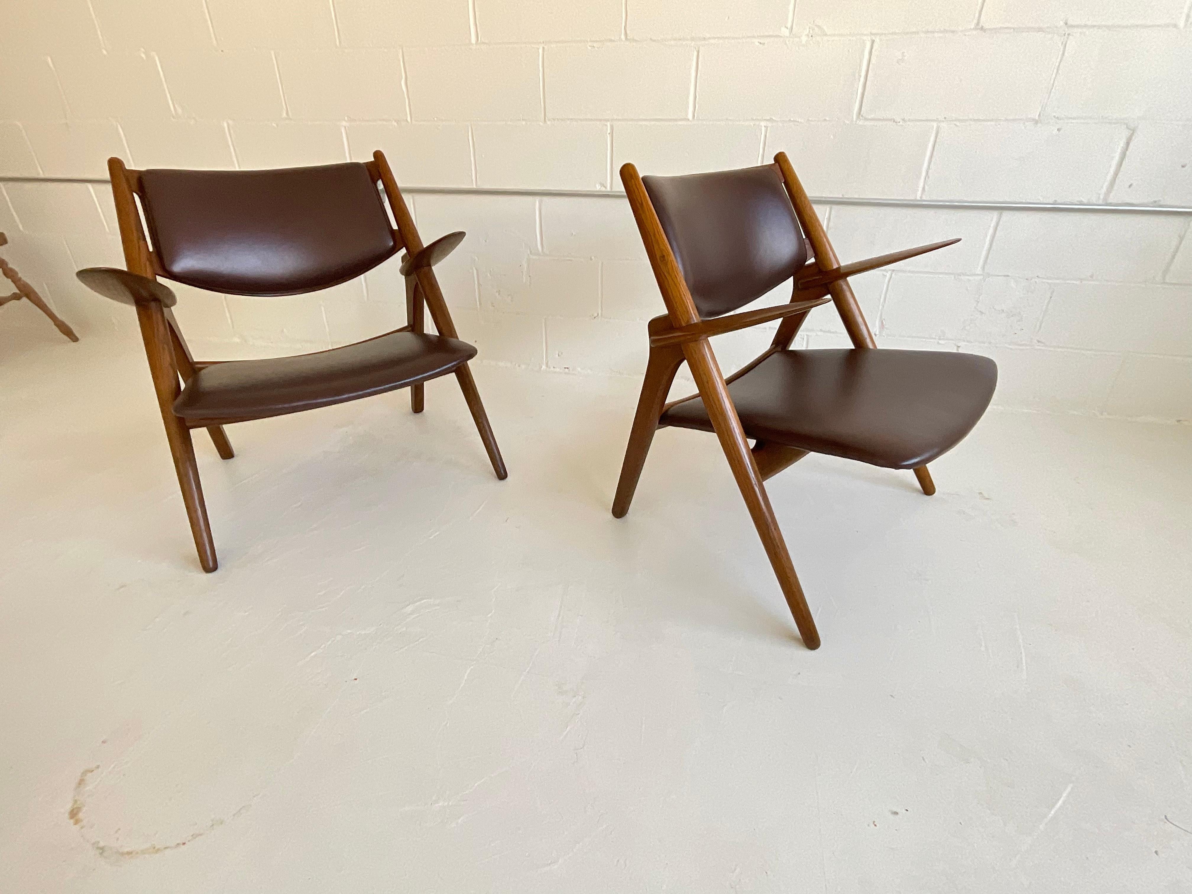 Eine Ikone des Sitzdesigns des 20. Jahrhunderts, die auch 72 Jahre nach ihrer Einführung noch gefeiert wird: der Sawbuck-Stuhl von Hans Wegner für Carl Hansen, 1951. Montaperto Studios freut sich, ein Vintage-Paar in Eiche und braunem, italienischem