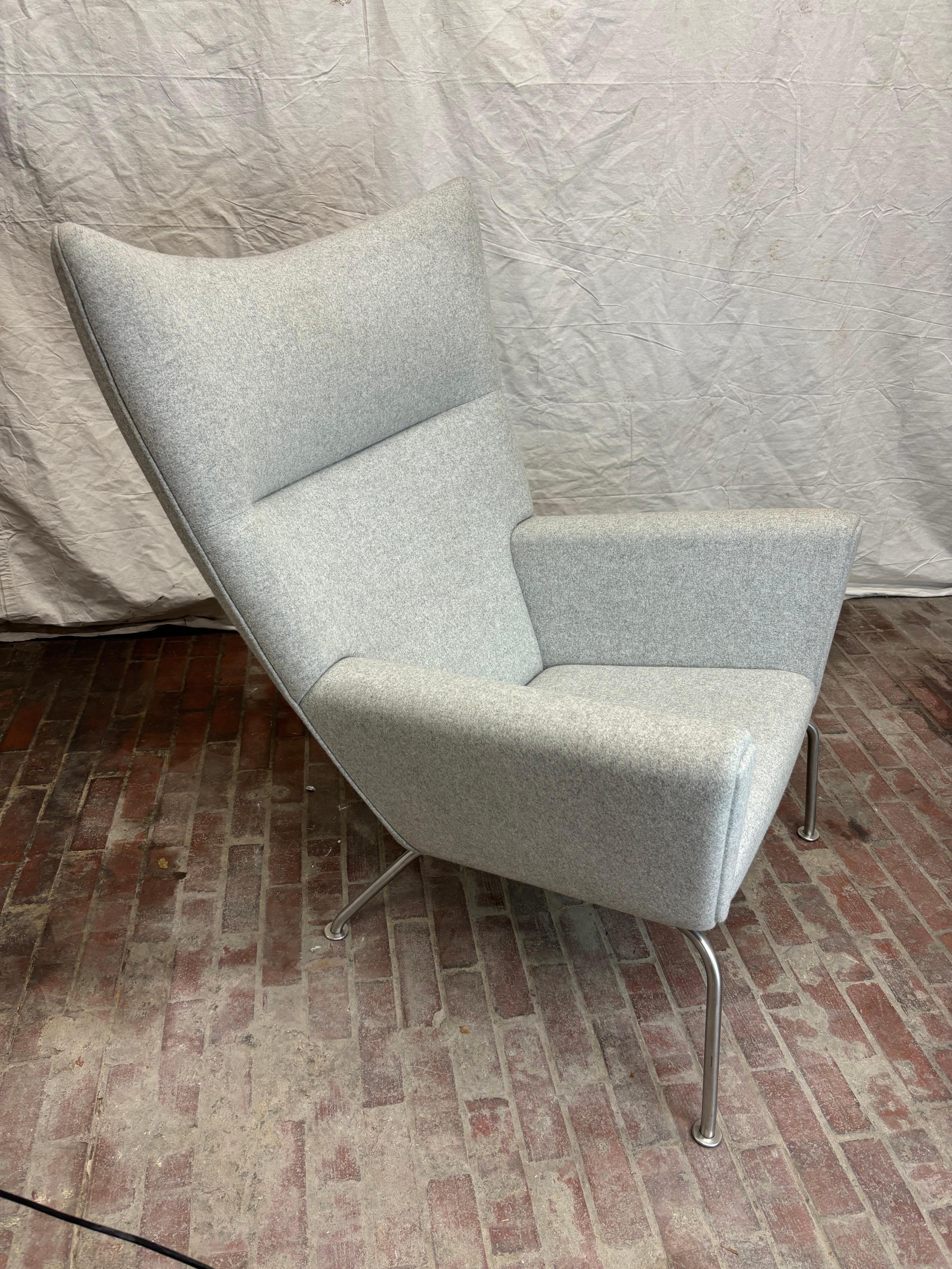 Chaise à oreilles Hans Wegner pour Carl Hansen & Son avec base en acier inoxydable.  Le design date du début des années 60 et Carl Hansen l'a réintroduit dans sa sélection.  Cette chaise n'a que quelques années.  Il a été utilisé pour un Show House