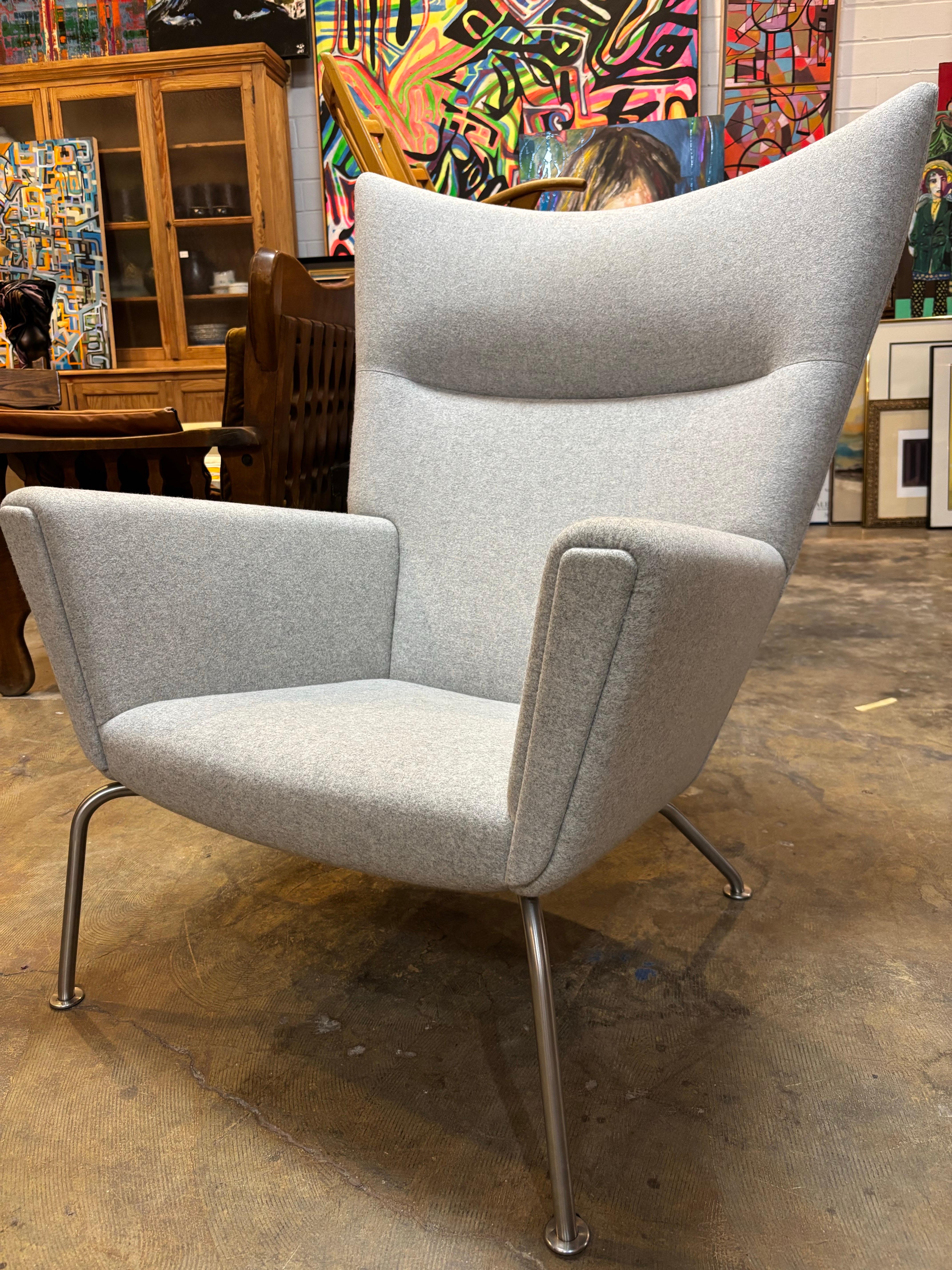 Hans Wegner Wing Lounge Chair CH445 für Carl Hansen & Son. Der Stuhl CH445 von Hans J. Wegner, auch bekannt als Wing Chair, ist ein vollgepolsterter Sessel, der auf einem Gestell aus Edelstahl ruht. Der Sessel mit seiner markanten Linienführung und