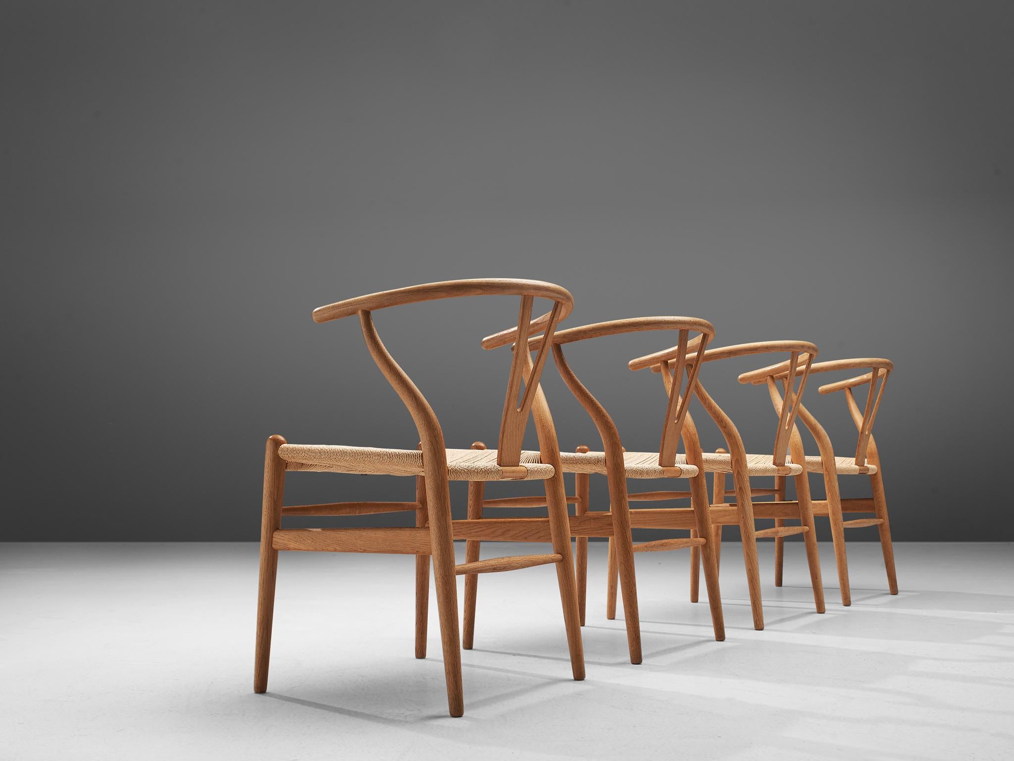 Hans J. Wegner for Carl Hansen and Sons, Set of four 'Whisbone' chairs model CH24, in oak and papercord, Denmark, 1949.

The Wishbone chair is one of the best known and most celebrated designs of Hans Wegner. A simplistic design with clean lines