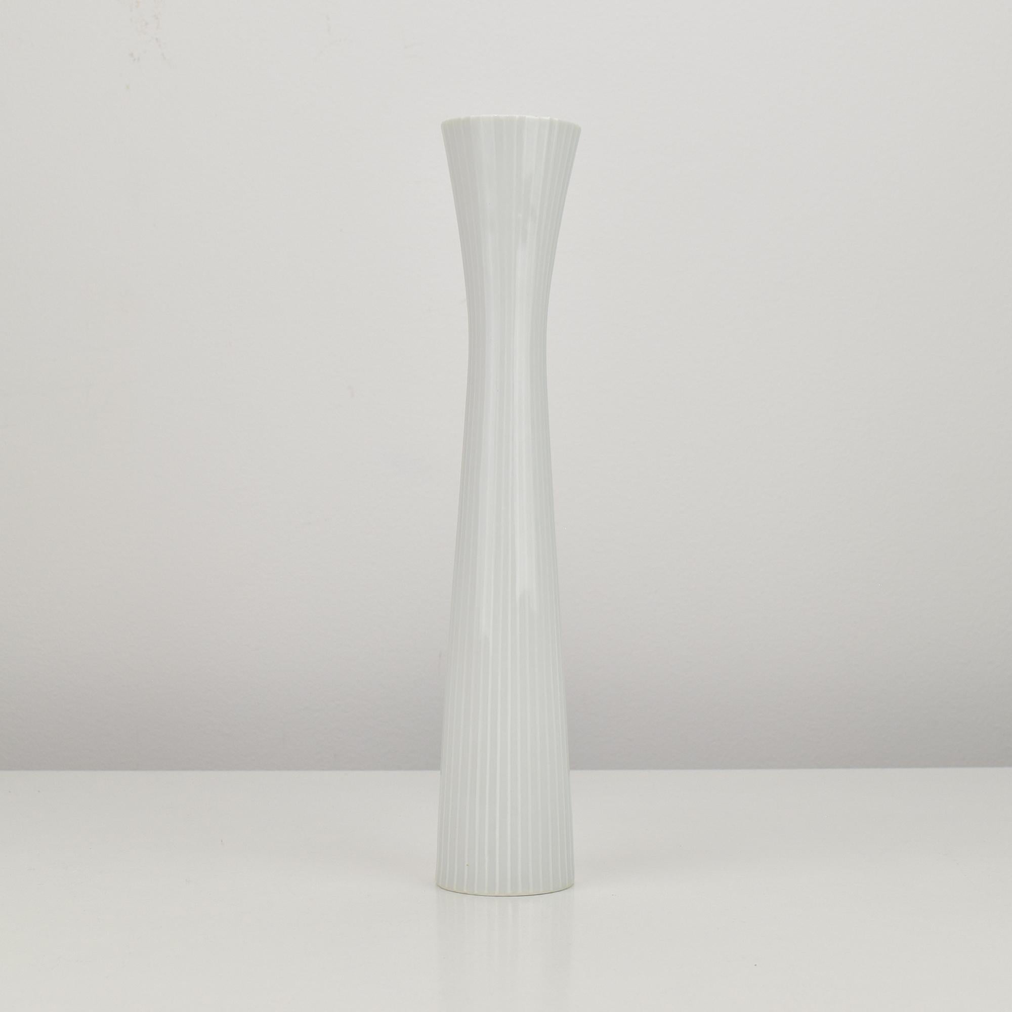 This elegant Rosenthal Studio-Line Diabolo vase was designed by Hans Wohlrab, showcasing the refined minimalism and sculptural quality characteristic of his mid-century work. Crafted from high-quality white porcelain, the vase features a fluted
