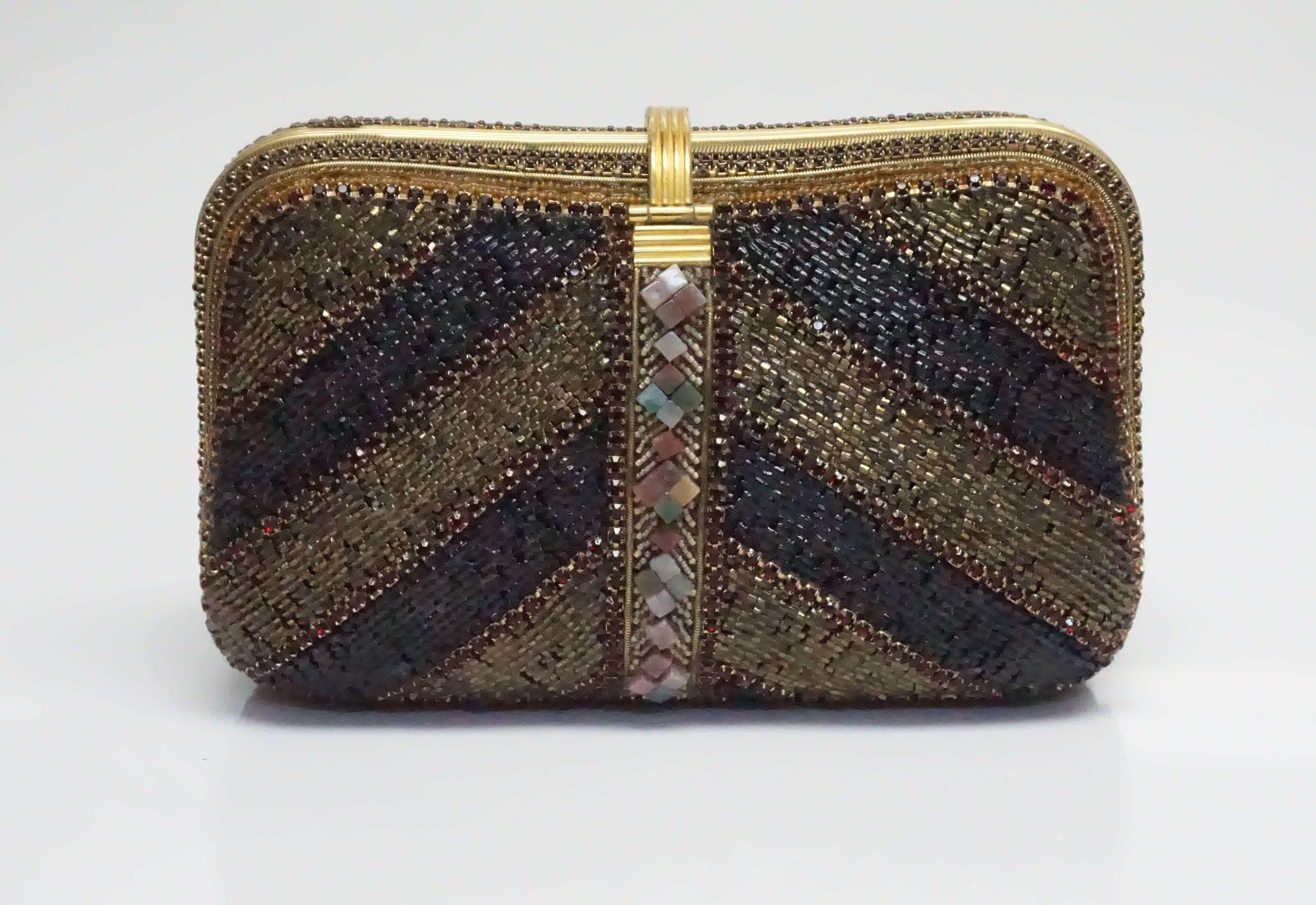 Hansen Designs Vintage Jeweled Clutch  This spectacular vintage piece is completely covered in jewels, beads, and stones. There is gold hardware throughout the clutch. Inside the clutch it is lined with fabric and has a side pocket. This bag can be