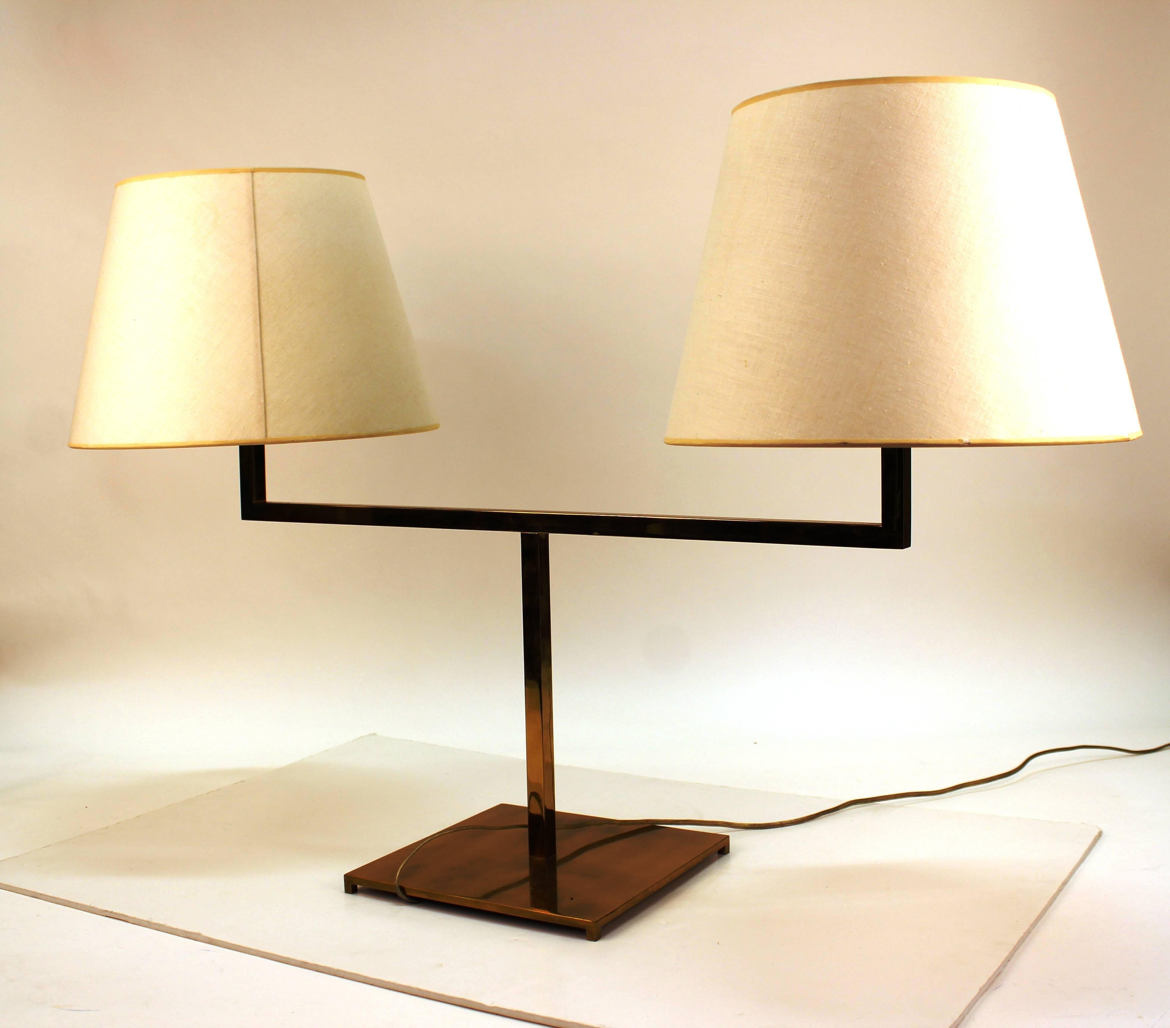 Hansen desk lamp in brass with rare double light. The piece stands on a square brass base and narrow neck with two arms. Each arm has two sockets and a pull chain. The lamp comes with the original shades, one with a small stain. Includes the maker's