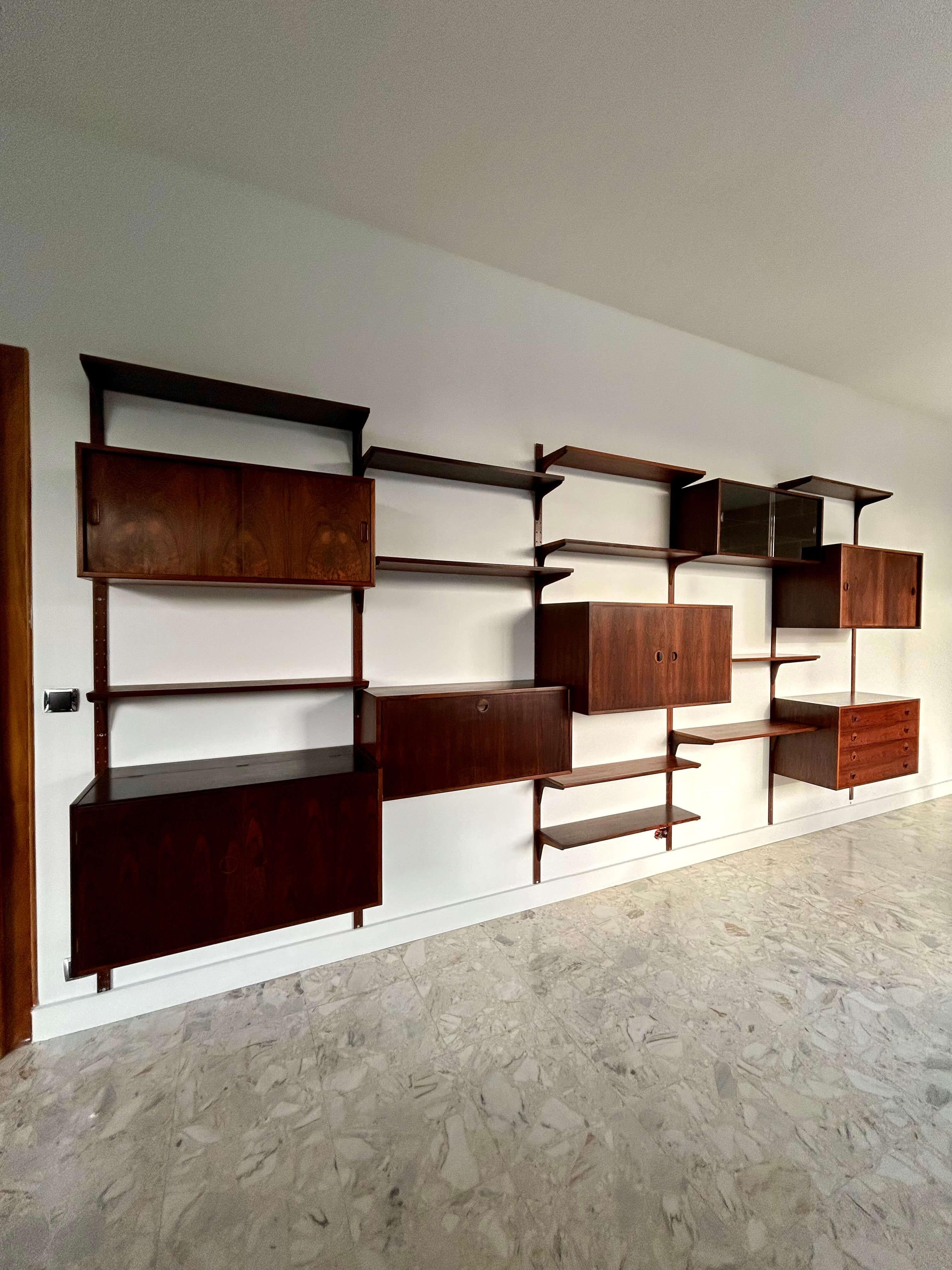 An important modular wall shelving system in rosewood, produced by Hansen & Guldborg Møbler in Denmark in the 1960s. Its simplicity and adaptability are typical of Scandinavian design, close to the designs of Poul Cadovius. This wall-mounted