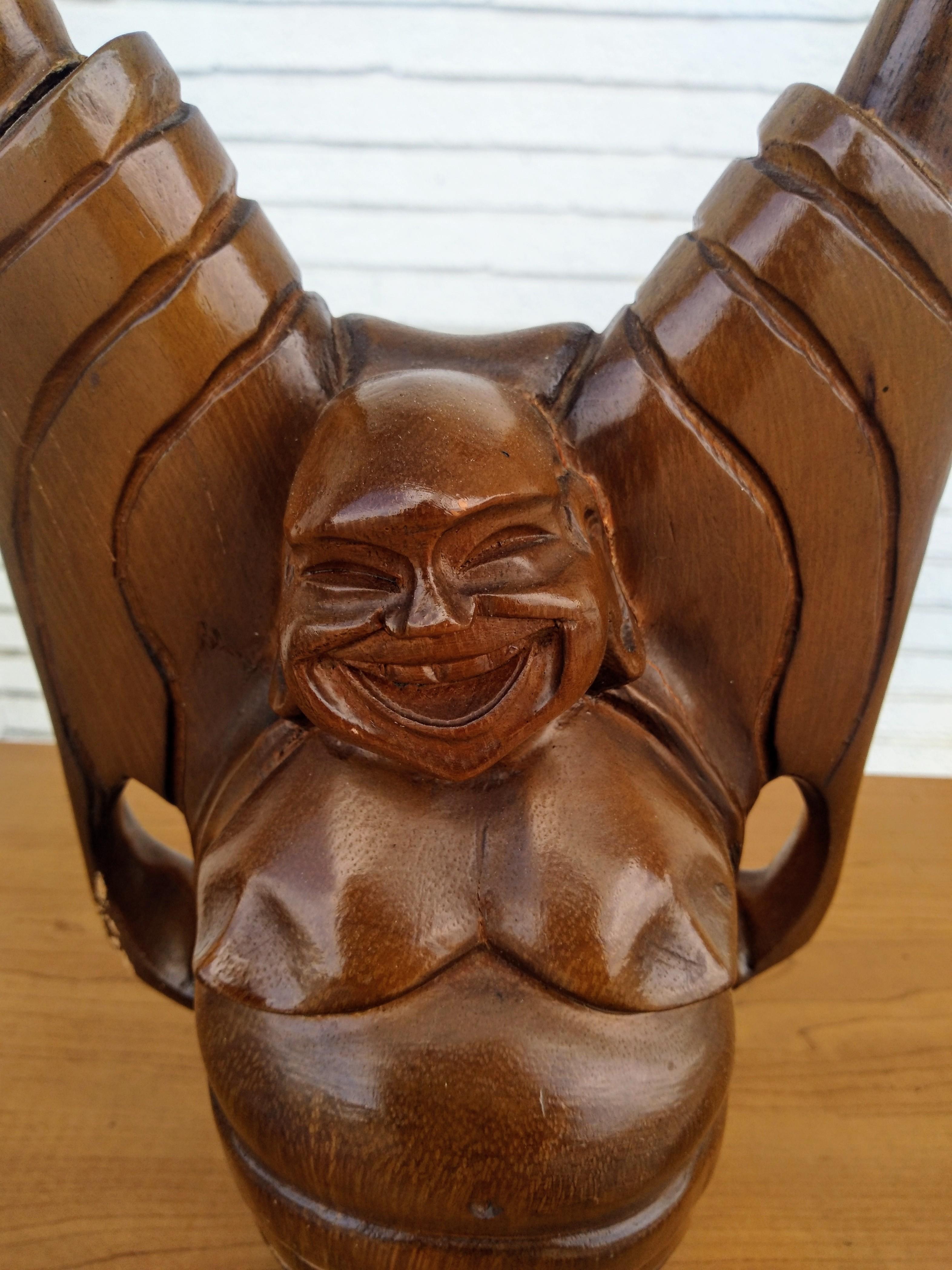 Si tratta di una scultura in legno intagliato di un Buddha felice. 