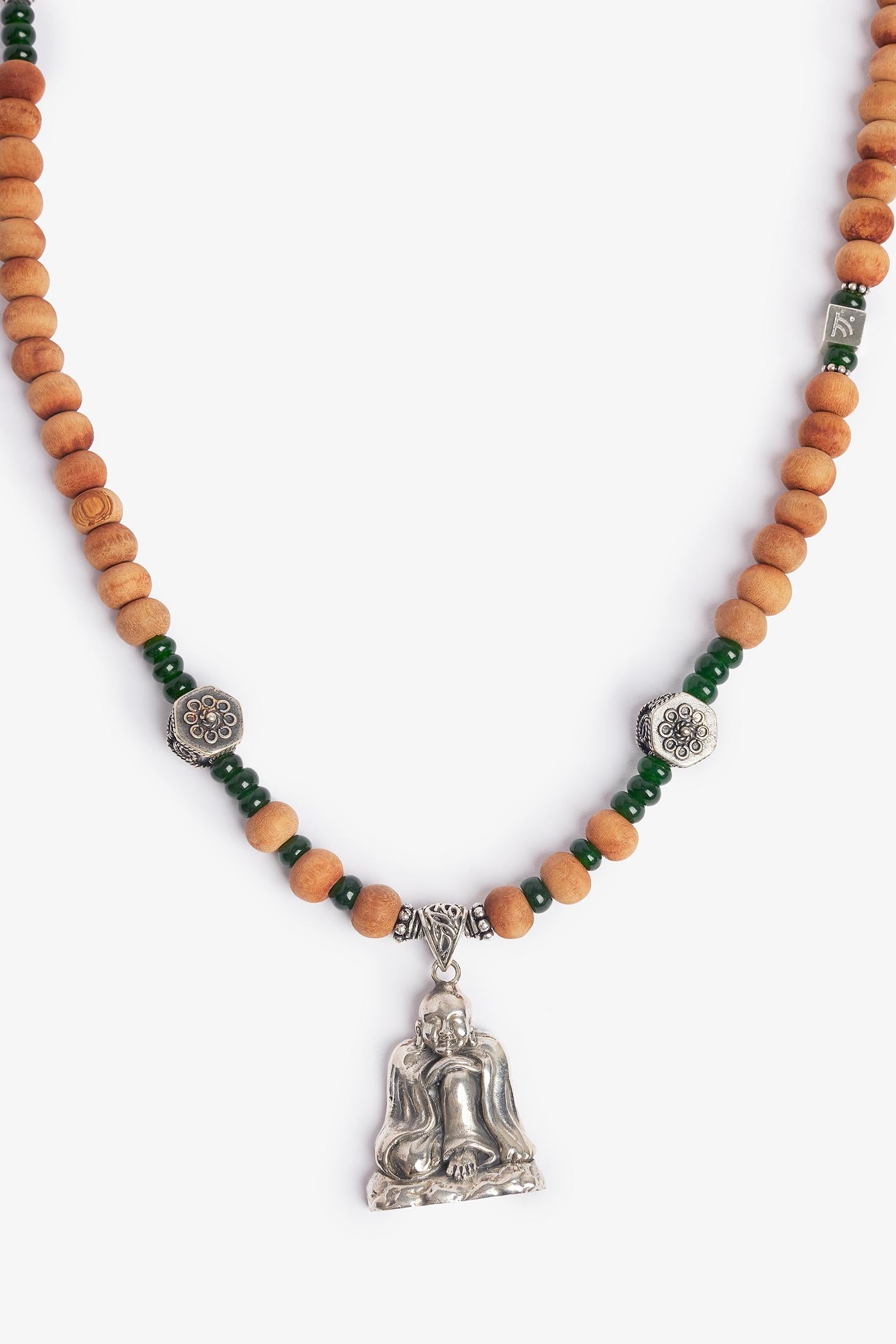 Happy buddha was made during the designer's travels to Bali.  The sandalwood was bought in a small market outside of Ubud, Bali.  The sterling silver Buddha was found in Java and the ornate silver elements are from Cheluk, Bali.  The necklace
