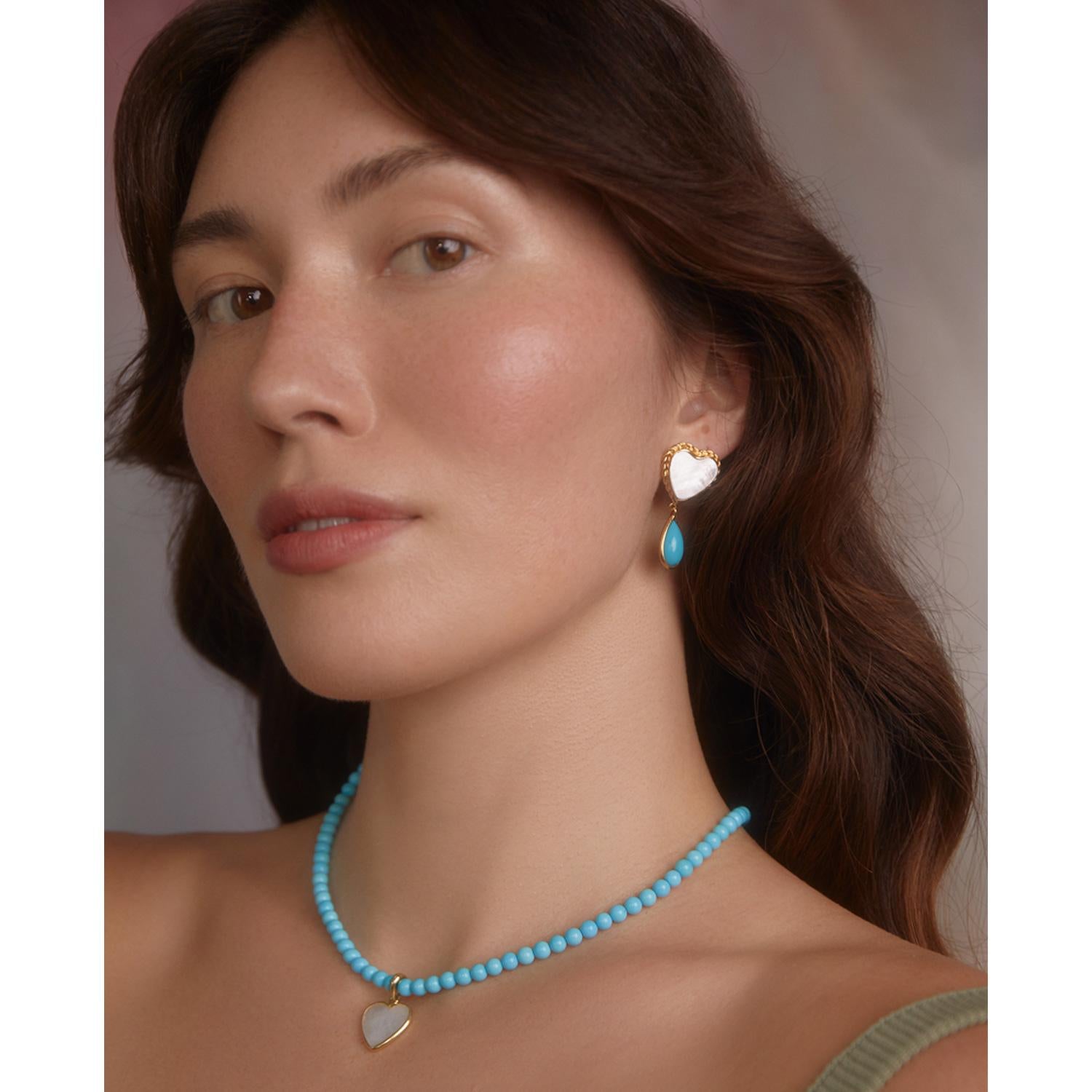 The Happy Heart necklace by Vintouch Jewels is centered with an iridescent mother of pearl heart-shaped pendant that sparkles like fresh morning dew. It is handmade in Italy from 24-karat gold vermeil and strung with natural turquoise beads in