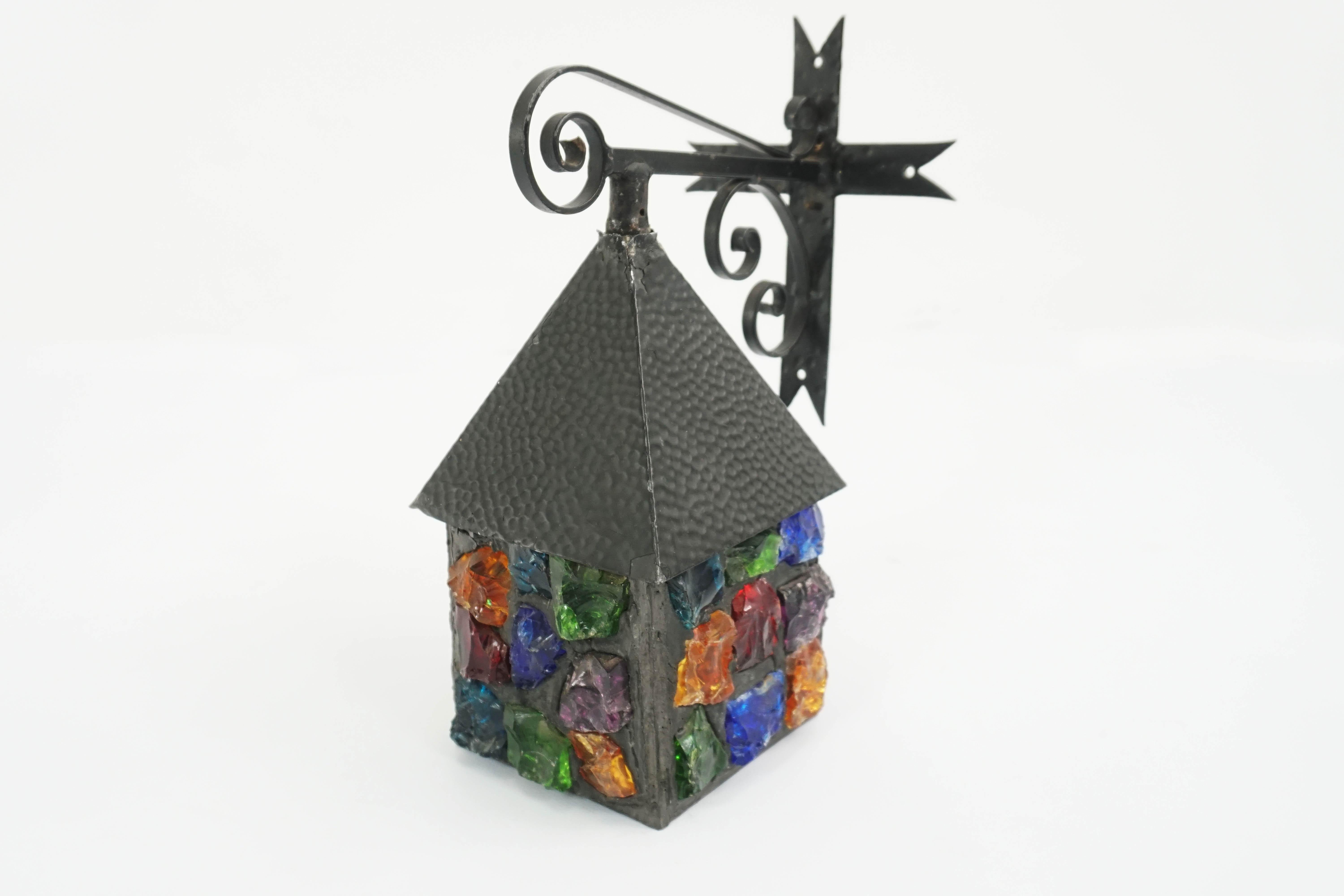 Outdoor lantern made with large pieces of broken colored glass that light up with magnificent colored light.
Very joyous in its form of a small house.