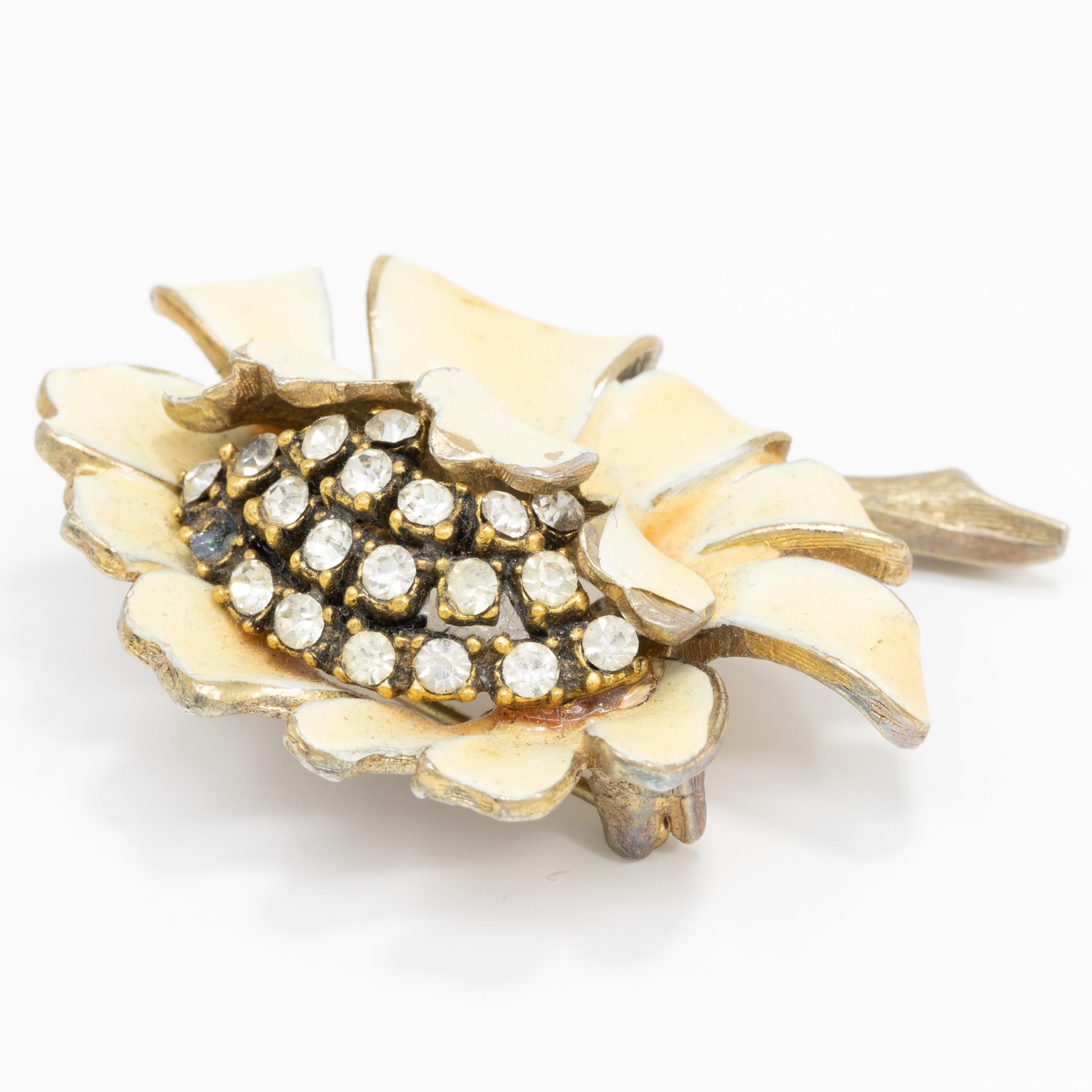 A blooming flower with a pave crystal center and petals painted in light yellow enamel.

Gold plated.

Marks / Hallmarks: HAR
