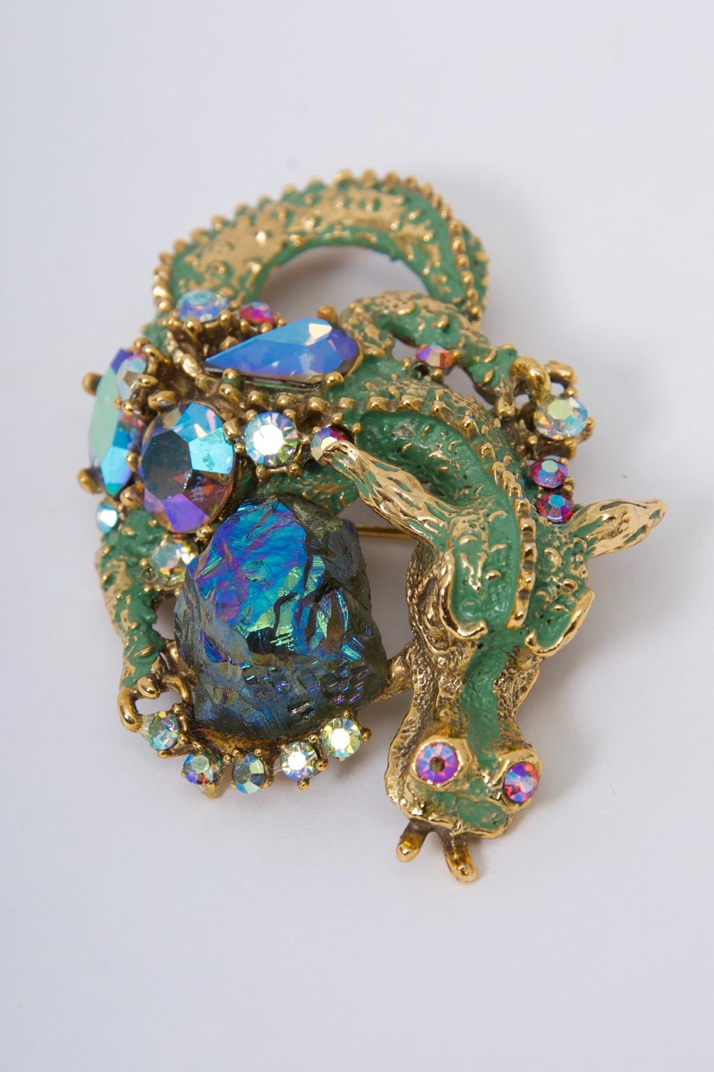 HAR dragon brooch fashioned of goldtone metal finished in green enamel and featuring the unusual lava stone as its central focus along with ABA rhinestones in various shapes and colors. Known for its idiosyncratic creations, HAR jewelry, founded by