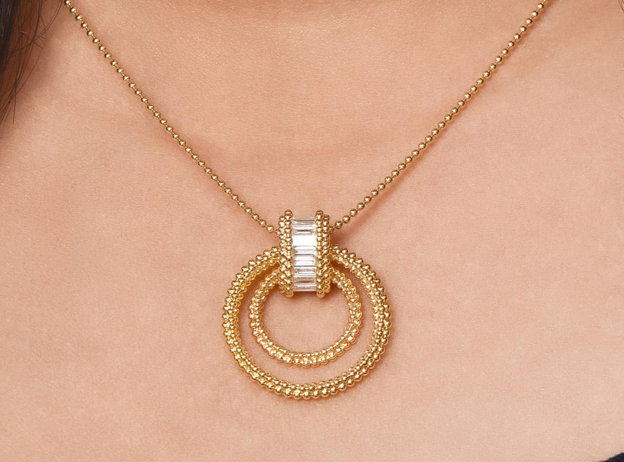 An elegant Sunlight Pendant consists of an oval shape pota ring studded with 18 custom cut baguettes, beautifully suspended with two dangling rings of different sizes. The complete look of the pendant is accentuated with the ancient pota technique