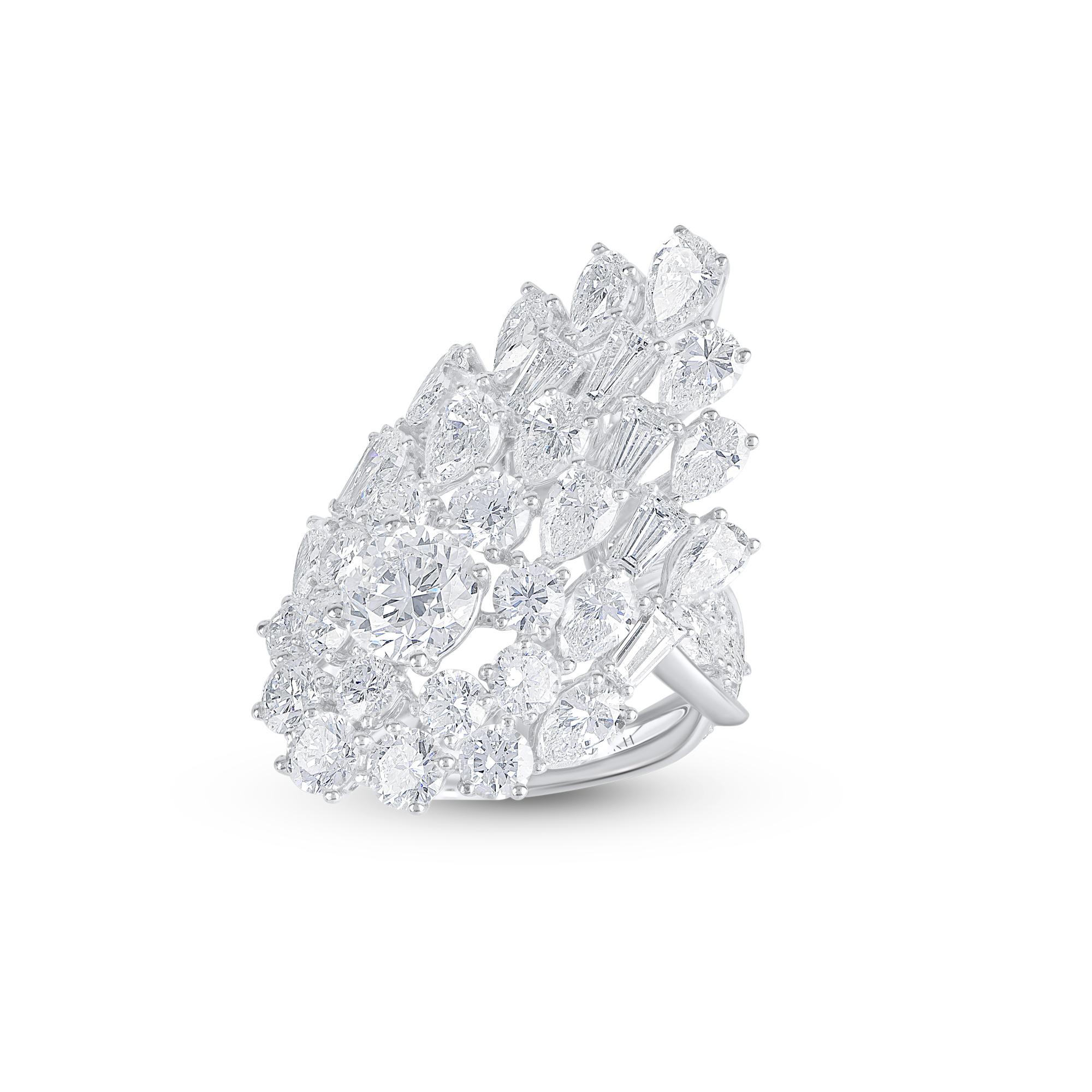 Designed in a unique way to mimic the handsome feathers of a blooming peacock, this ring is studded with 60 brilliant round diamonds including a GIA certified 1.01 carat center stone, 7 baguettes and 18 pear shaped diamonds and is crafted in 18 kt