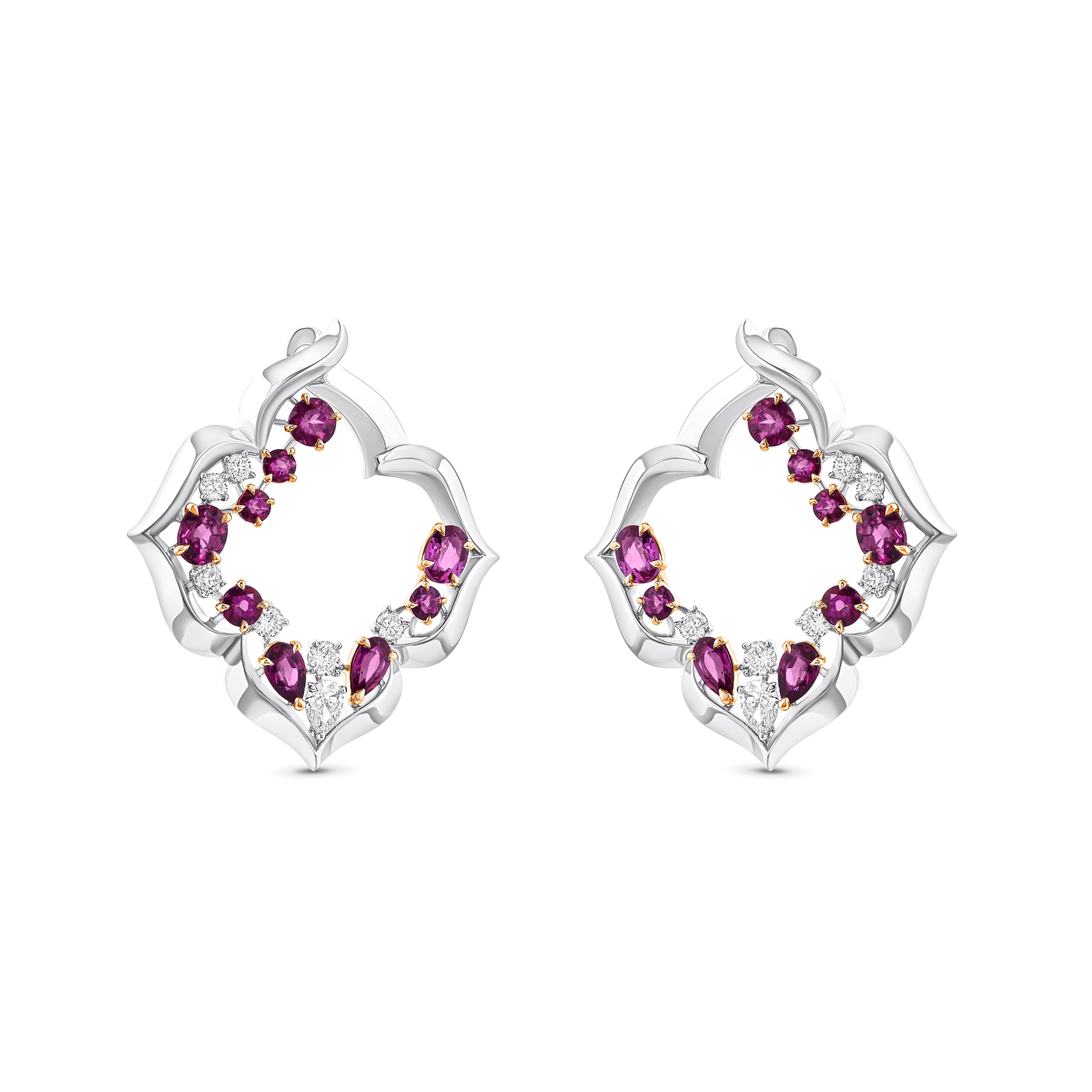 Inspired by the sacred symbols to invoke divinity, these elegantly designed earrings are studded with 4 oval cut ruby, 4 pear cut ruby, 10 round ruby, 2 pear-cut diamonds, and 12 brilliant round diamonds, for a total of 3/4 carats of natural