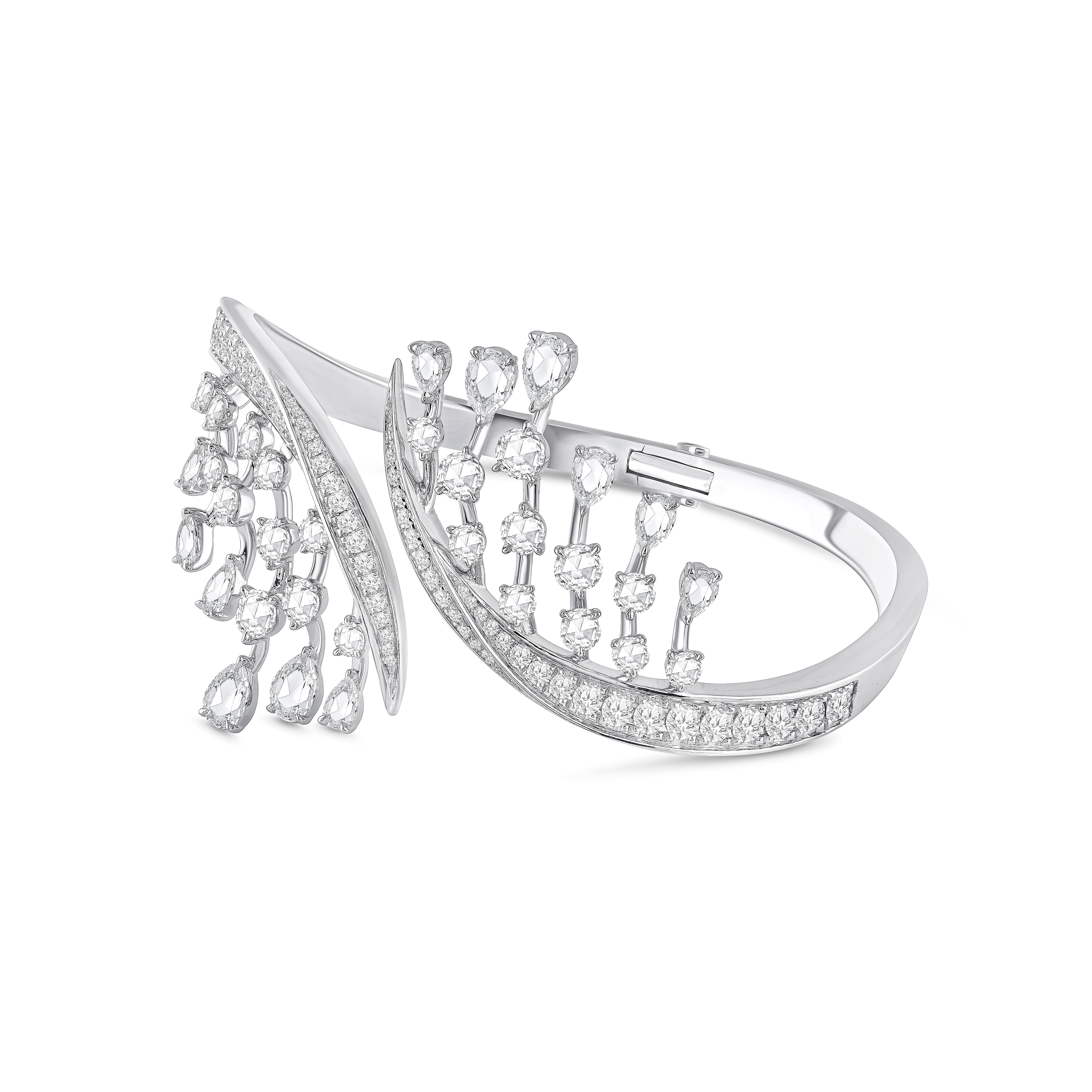 Dieser Bypass-Armreif mit Scharnier ist Teil unserer Cascade Collection'S. Er ist mit runden und birnenförmigen Brillanten in Pave- und Krallenfassung mit insgesamt 70 Diamanten besetzt.  

Dieser wunderschöne Armreif besteht aus 38 runden