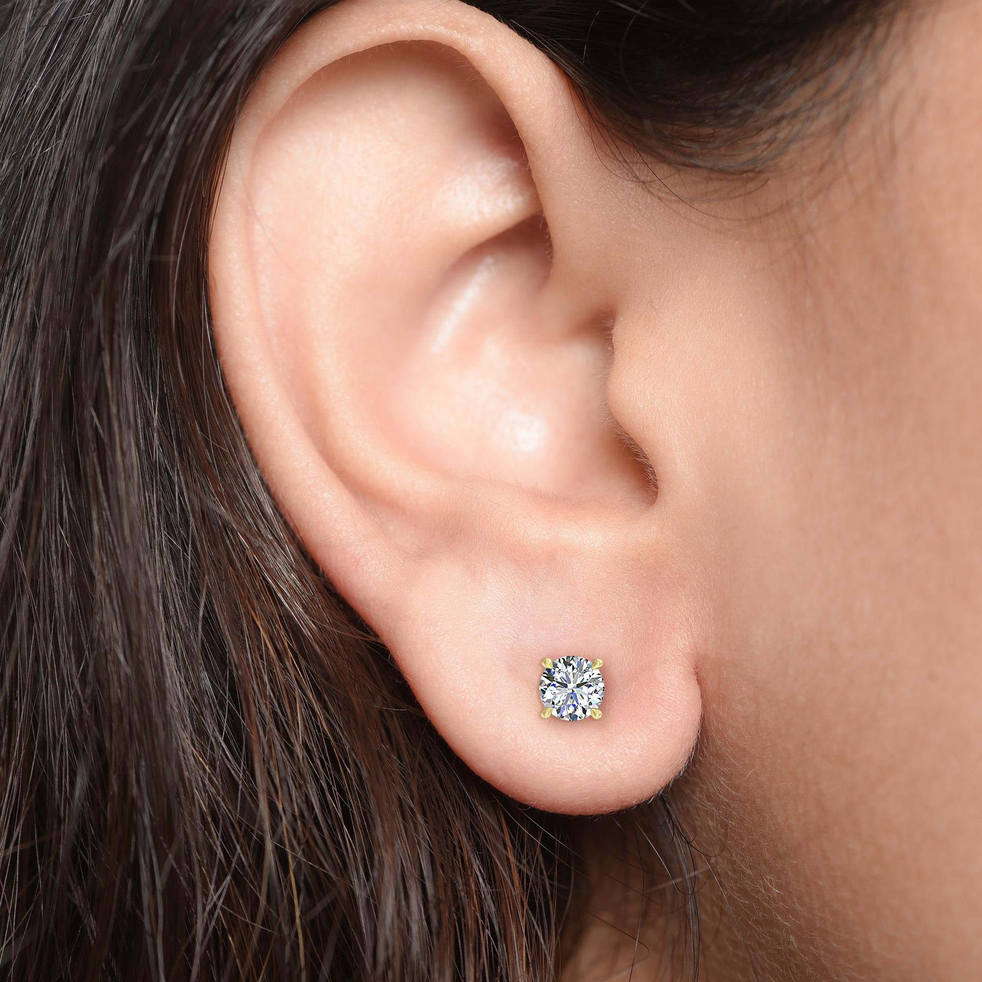 Diese klassischen GIA-zertifizierten Diamantohrstecker präsentieren ein Paar perfekt aufeinander abgestimmter Diamanten mit einem Gesamtgewicht von 0,68 Karat. Die aus 18-karätigem Gelbgold gefertigten vierzackigen Ohrringe sind auch in Weiß- und