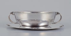 Harald Nielsen for Georg Jensen. Sterling silver bowl with handles on a saucer.