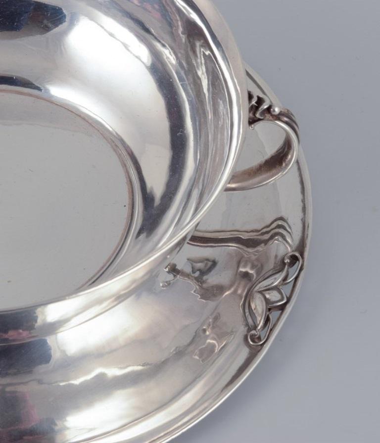 Art Nouveau Harald Nielsen for Georg Jensen. Sterling silver bowl with handles on a saucer. For Sale