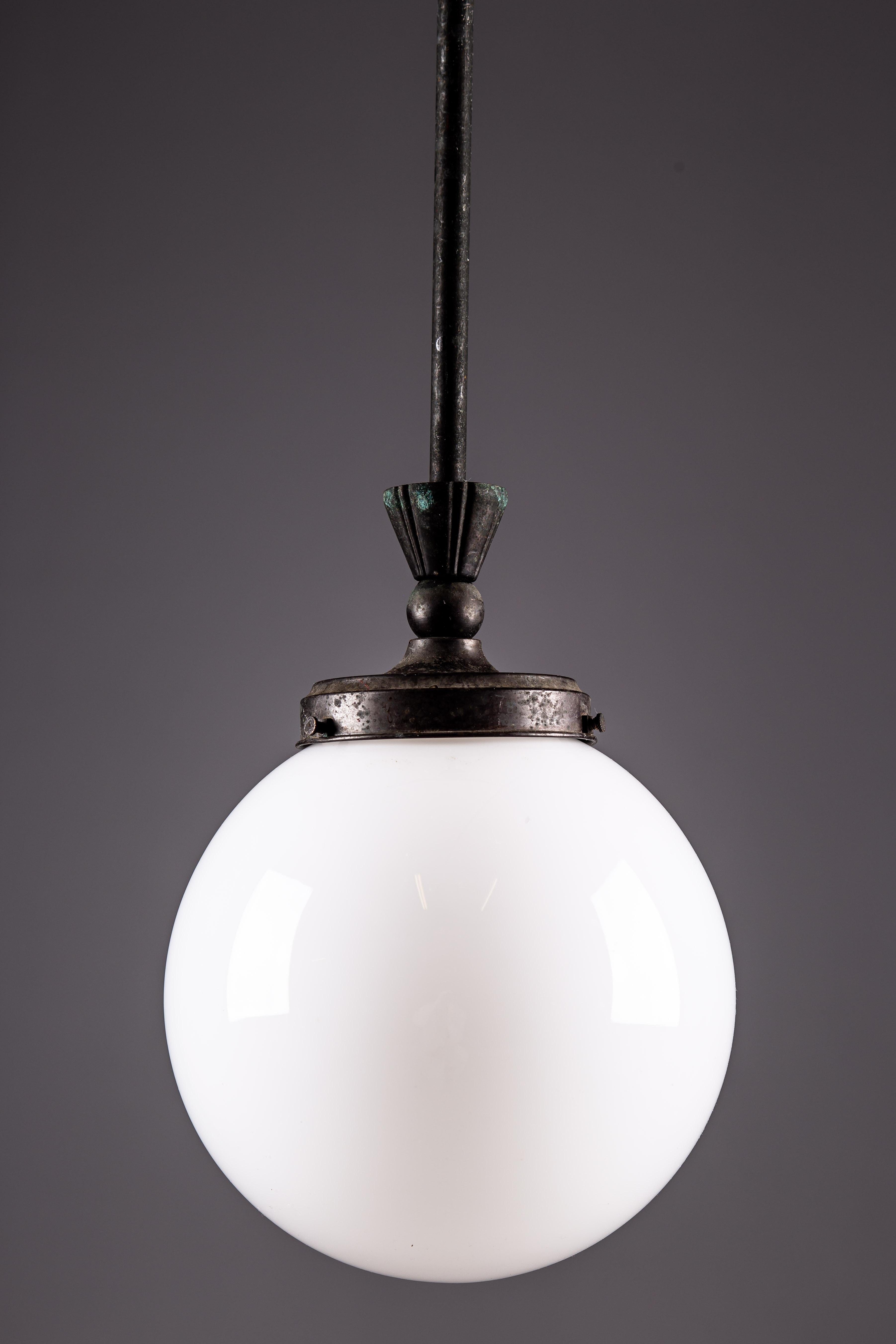 Ti presentiamo la lampada da soffitto degli anni '20 di Harald Notini di Arvid Böhlmarks Lampfabrik, Svezia; un pezzo senza tempo di design scandinavo vintage. Realizzata con una finitura in metallo patinato scuro, questa lampada emana una sobria