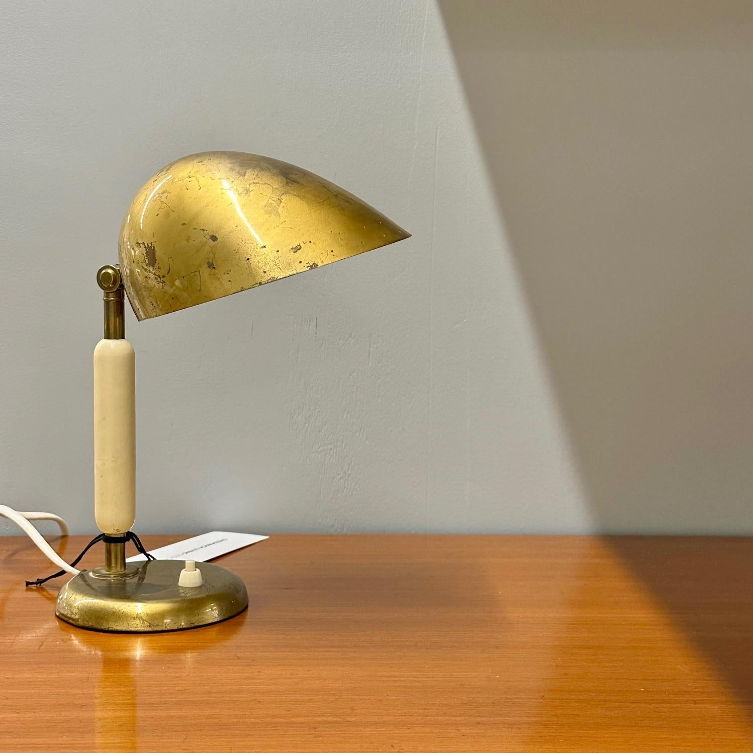 Mid-century modern swedish table or desk lamp designed by Harald Notini (Sweden, 1879-1959) for Arvid Böhlmarks Lampfabrik in Sweden circa 1930/40s.

Heavily patinated perforated brass shade and brass base. The fixture body is is a beige lacquered