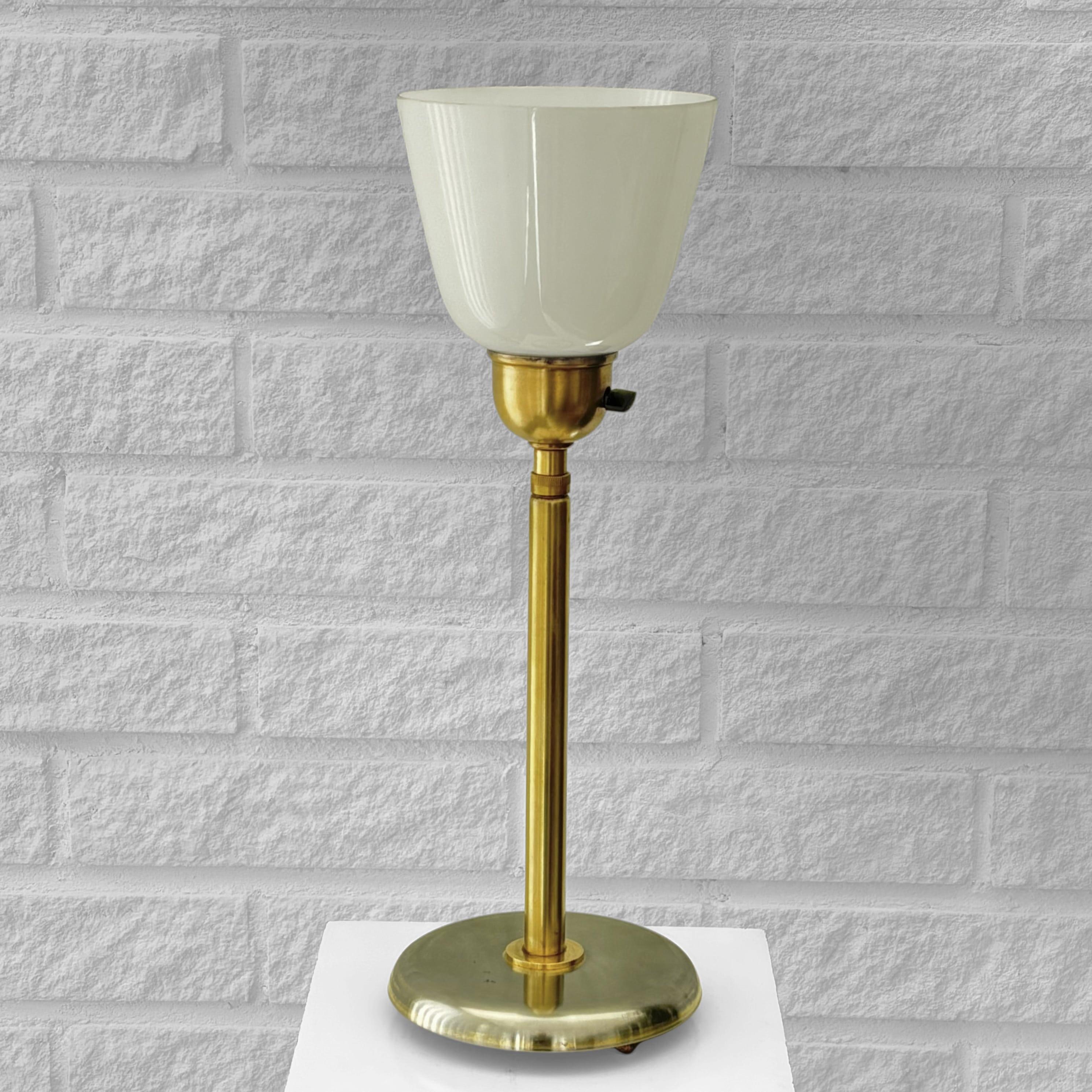A table lamp, model 15505, designed by Harald Notini for the renowned Swedish manufacturer Arvid Böhlmarks Lampfabrik in the 1940s. Crafted from brass with a circular steel base, this piece features a telescopic stem that allows the height to be