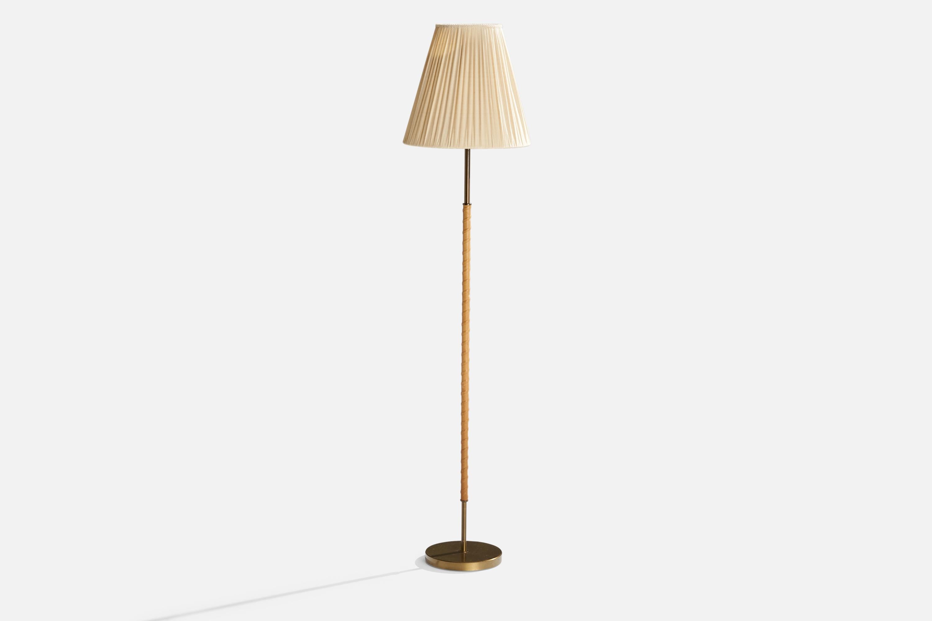 A brass, leather and light beige fabric floor lamp designed by Harald Notini and produced by Böhlmarks, Sweden, 1940s.

Overall Dimensions (inches):62.25” H x 14” W x 16.25” D
Stated dimensions include shade.
Bulb Specifications: E-26 Bulb
Number of