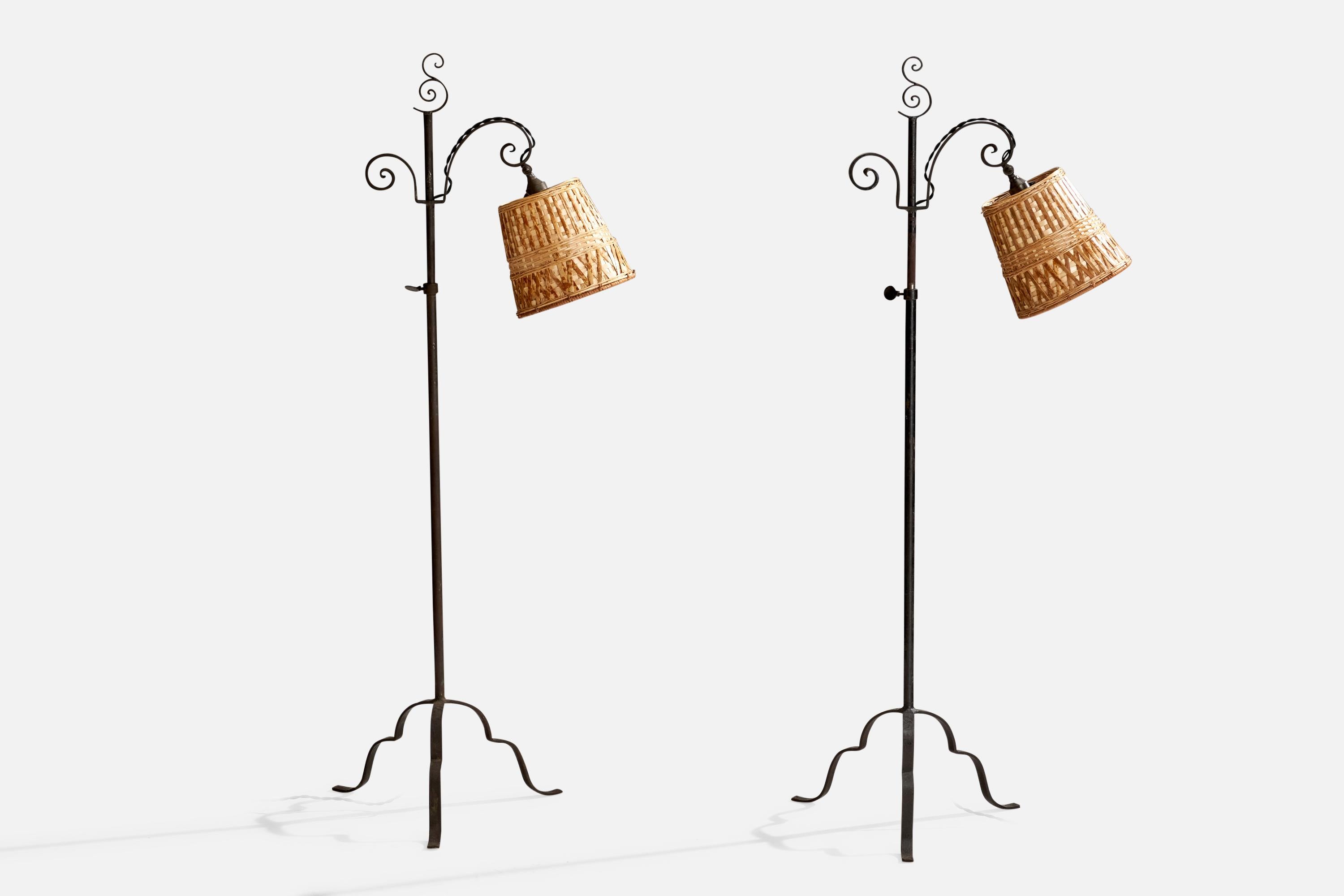 A pair of adjustable wrought iron and rattan floor lamps designed by Harald Notini and produced by Böhlmarks, Sweden, 1930s.

Assorted vintage rattan lampshades.
Adjustable Height
Dimensions of Lamp with Shade (inches): 48.875” H x 16” W x 22.5” D