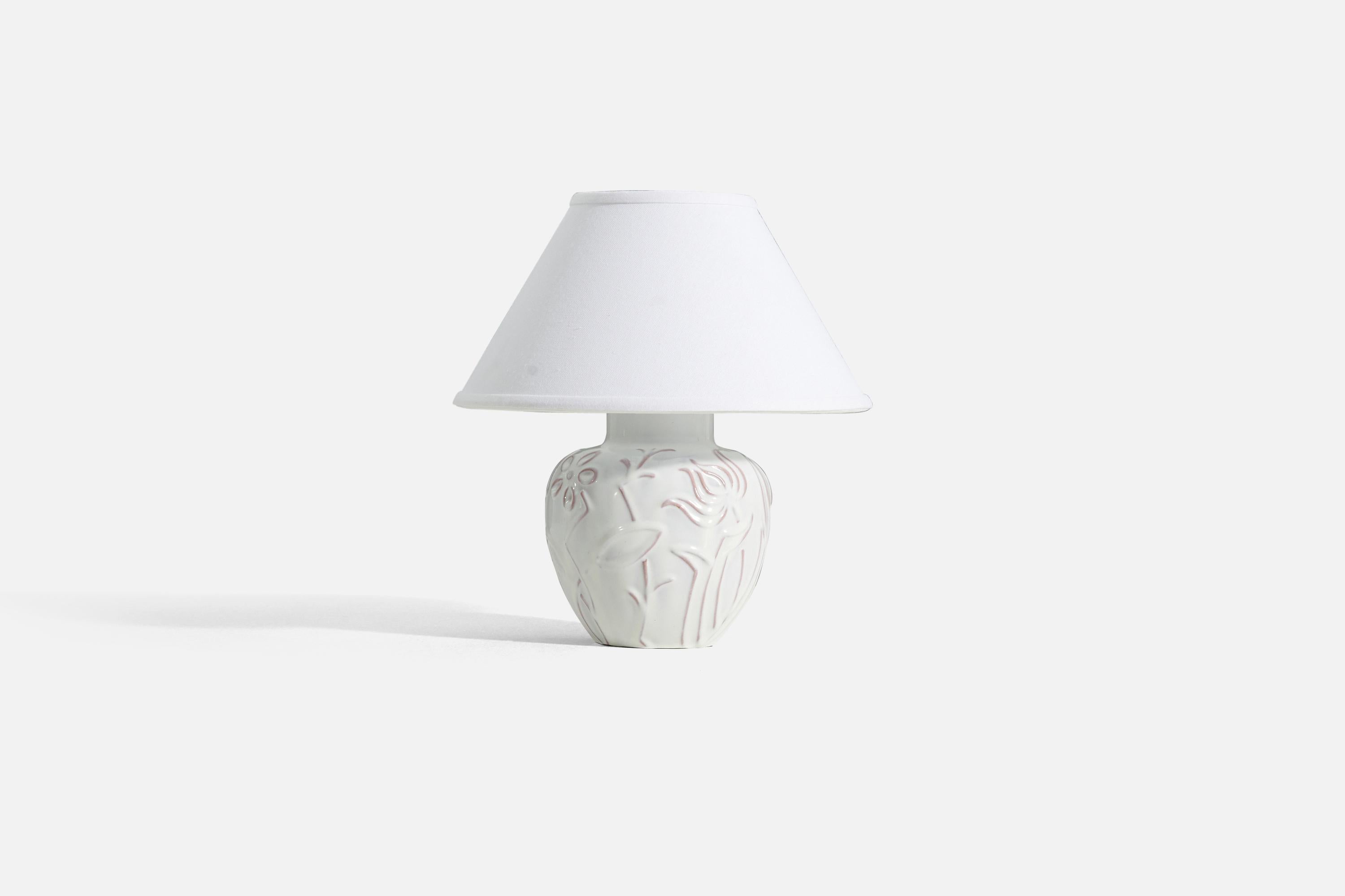 A white-glazed earthenware table lamp designed by Harald Östergren, produced by Upsala-Ekeby, Sweden, 1940s. Lamp features a floral / flower motif. 

Measurements listed are of lamp itself. Sold without lampshade.
Measurements of shade : 5 x