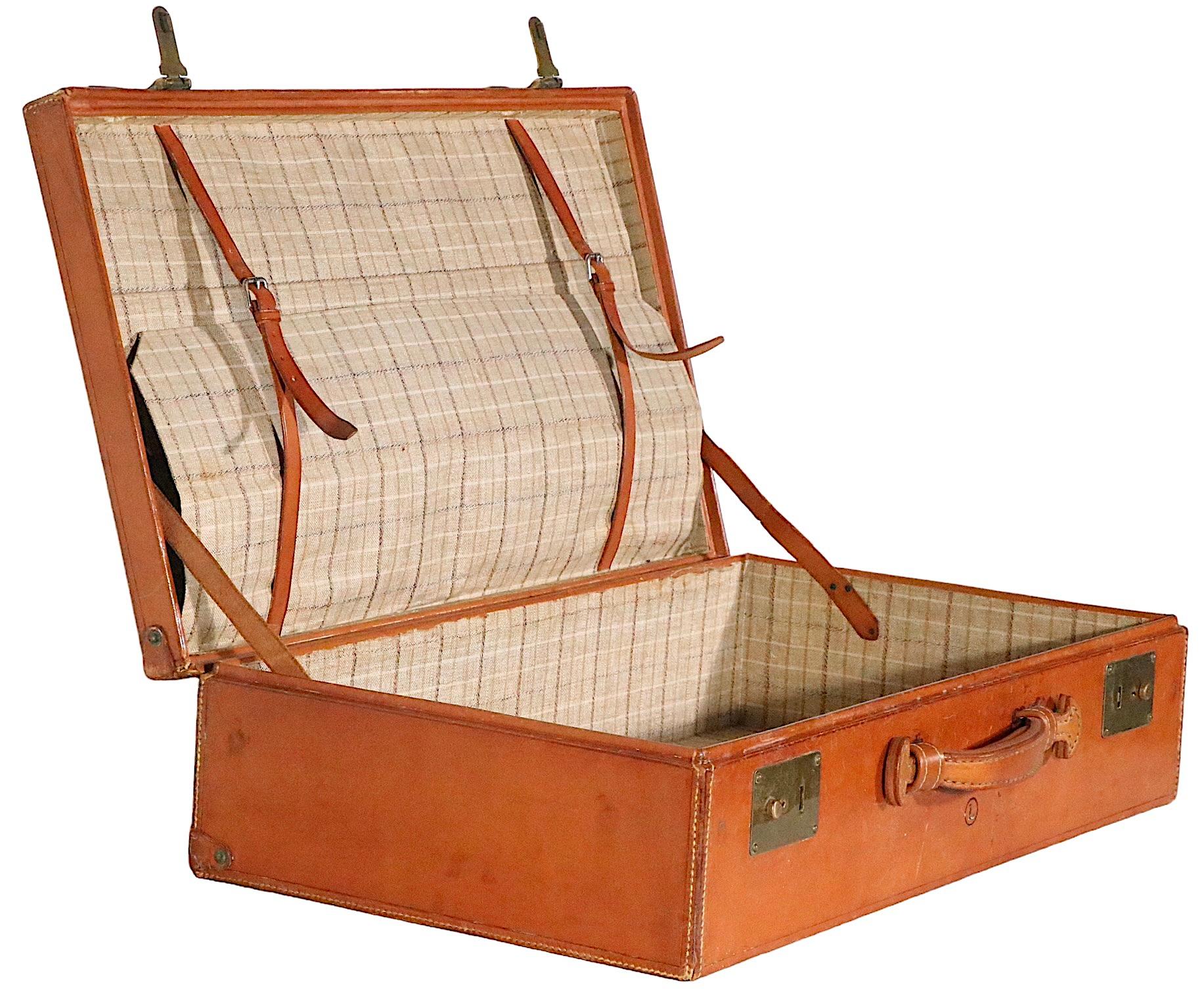 Chic vintage overnight suitcase in very fine, original condition, attributed to high end maker, Crouch & Fitzgerald. Exception craftsmanship, voguish and sophisticated , usable for travel or just as a decorative objet. The case includes its original