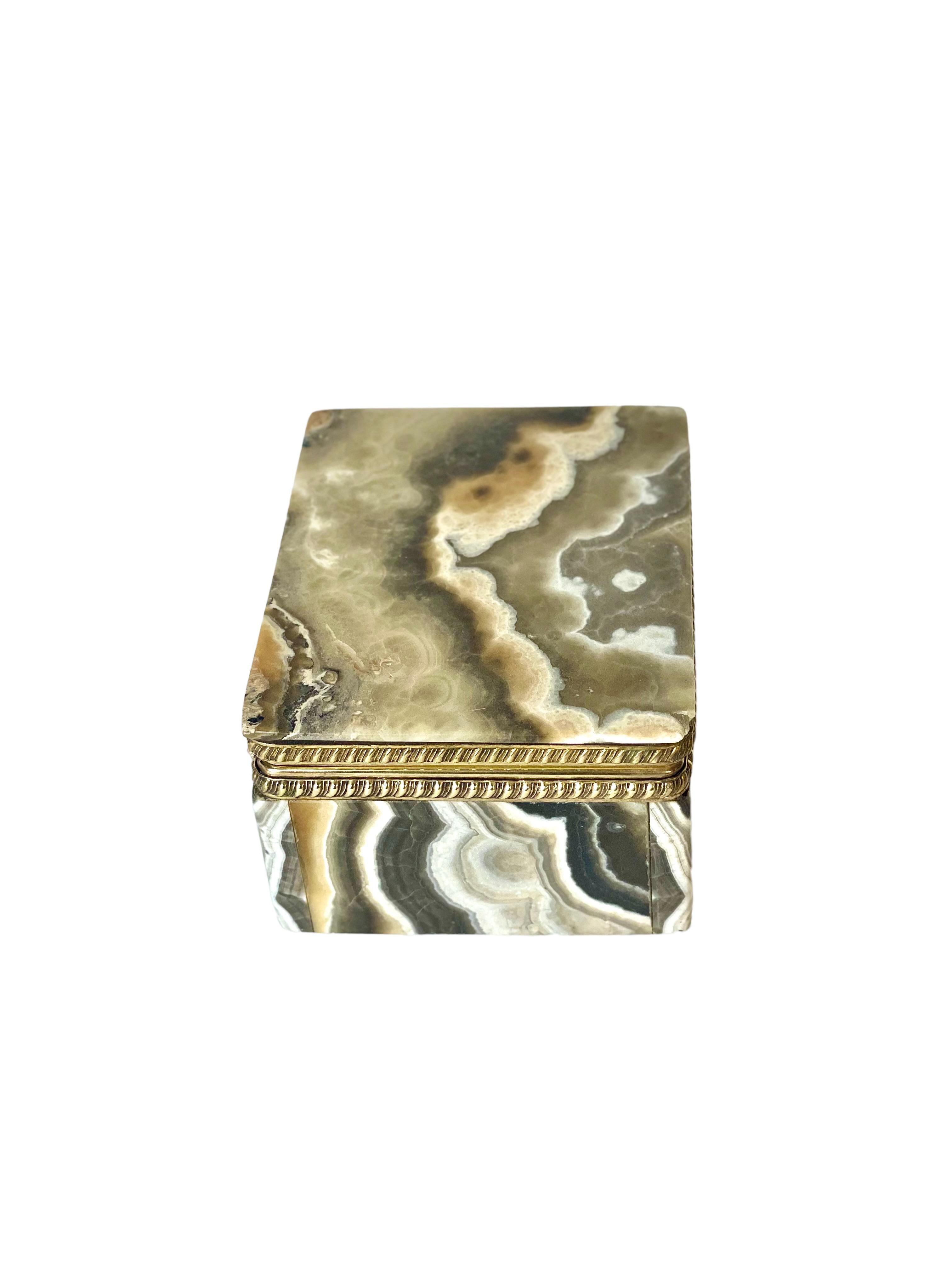 An attractive little Agate lidded jewelry, or trinket, box made by Christian Dior, decorated with a gadrooned frieze in gilt brass. Made from finely cut hard stone, this diminutive and very stylish casket would make an ideal place to store