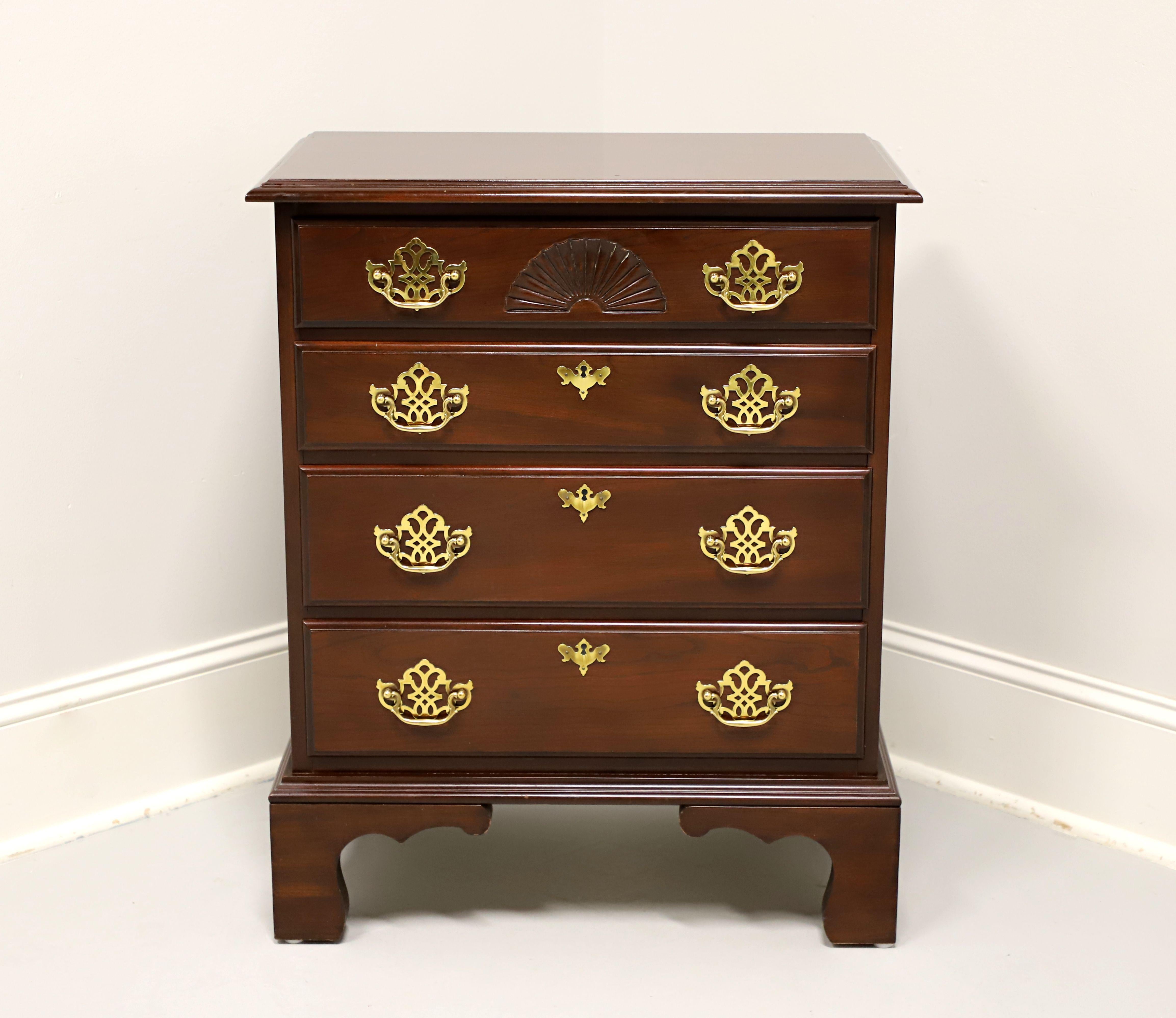 A Chippendale style bedside chest by Harden Furniture. Cherry wood with brass hardware, bevel edge to the top, and bracket feet. Features four drawers of dovetail construction, top drawer having a carved open fan and three lower drawers with faux