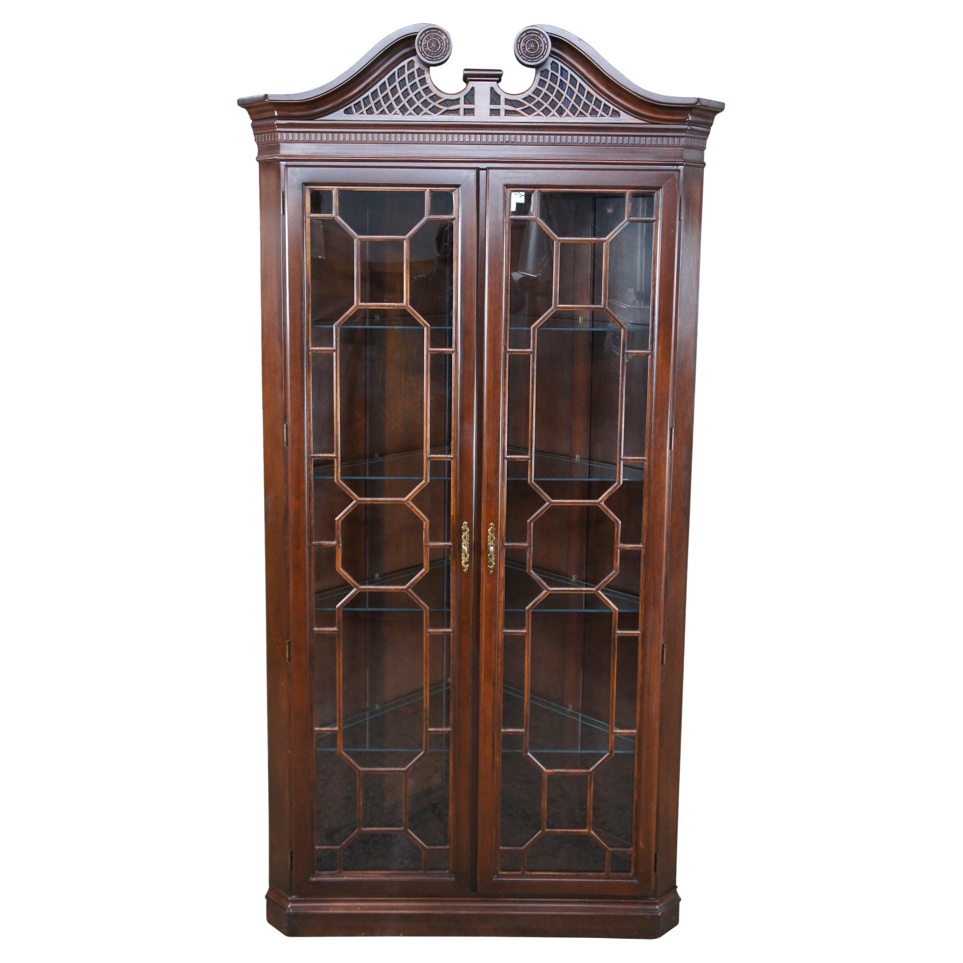 Harden Furniture American Cherry Illuminated corner cabinet, circa 1980s. Features Chippendale or Georgian styling with fretwork trimmed glass doors, an open pediment with pierced lattice work and dentil molding. Includes four glass shelves with