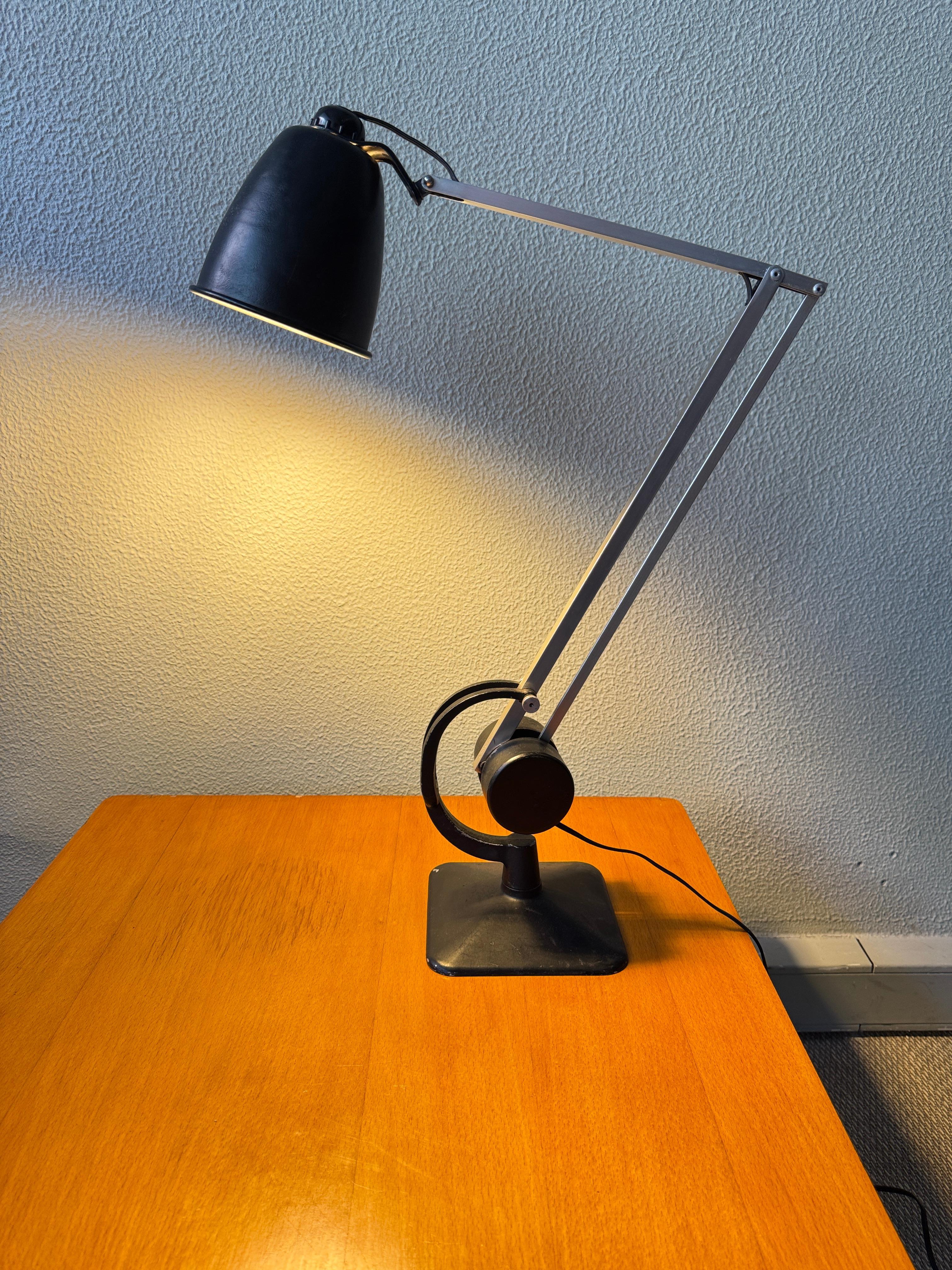 Esta lámpara de trabajo regulable fue producida en la década de 1950 por Hardill & Horstmann Ltd., un fabricante inglés con sede en Godalming, conocido por su ingeniería precisa y la adopción temprana de los principios del diseño industrial moderno.