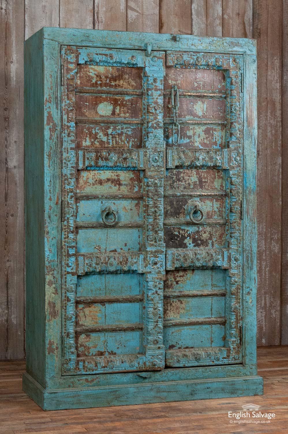 Useful cupboard made from antique Indian doors and reclaimed hardwood. Would make a good linen cupboard or kitchen cupboard as it has three fixed internal shelves. Painted an attractive blue / turquoise over yellow and brown with crackle paint
